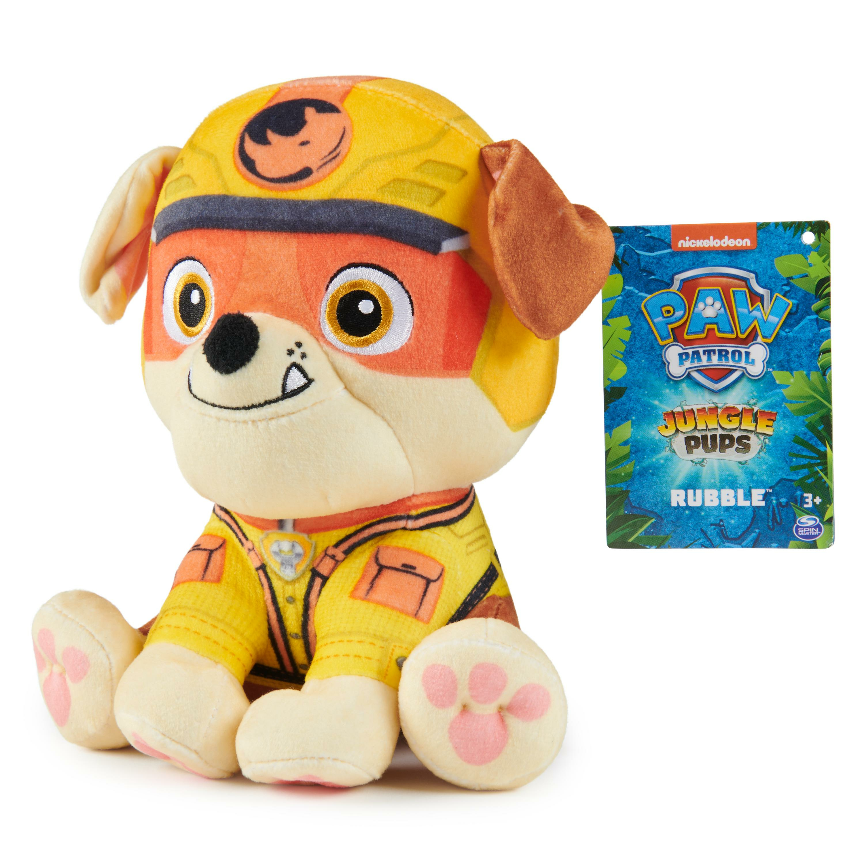 Ein Paw Patrol Rubble-Plüschtier sitzt mit einem Anhänger. Das Spielzeug ist gelb und orange.