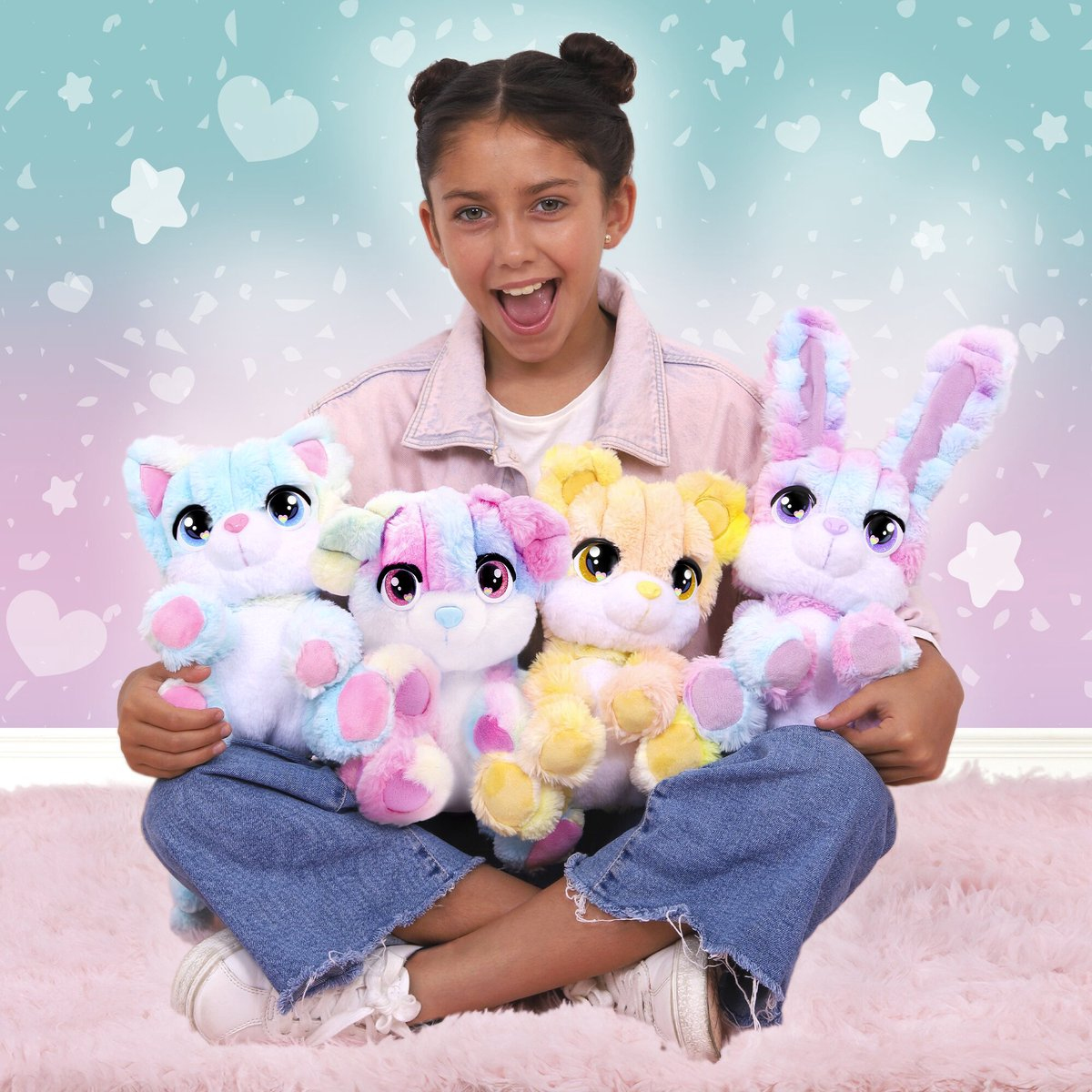 A young girl smiling, holding four colorful plush toys shaped like animals.
