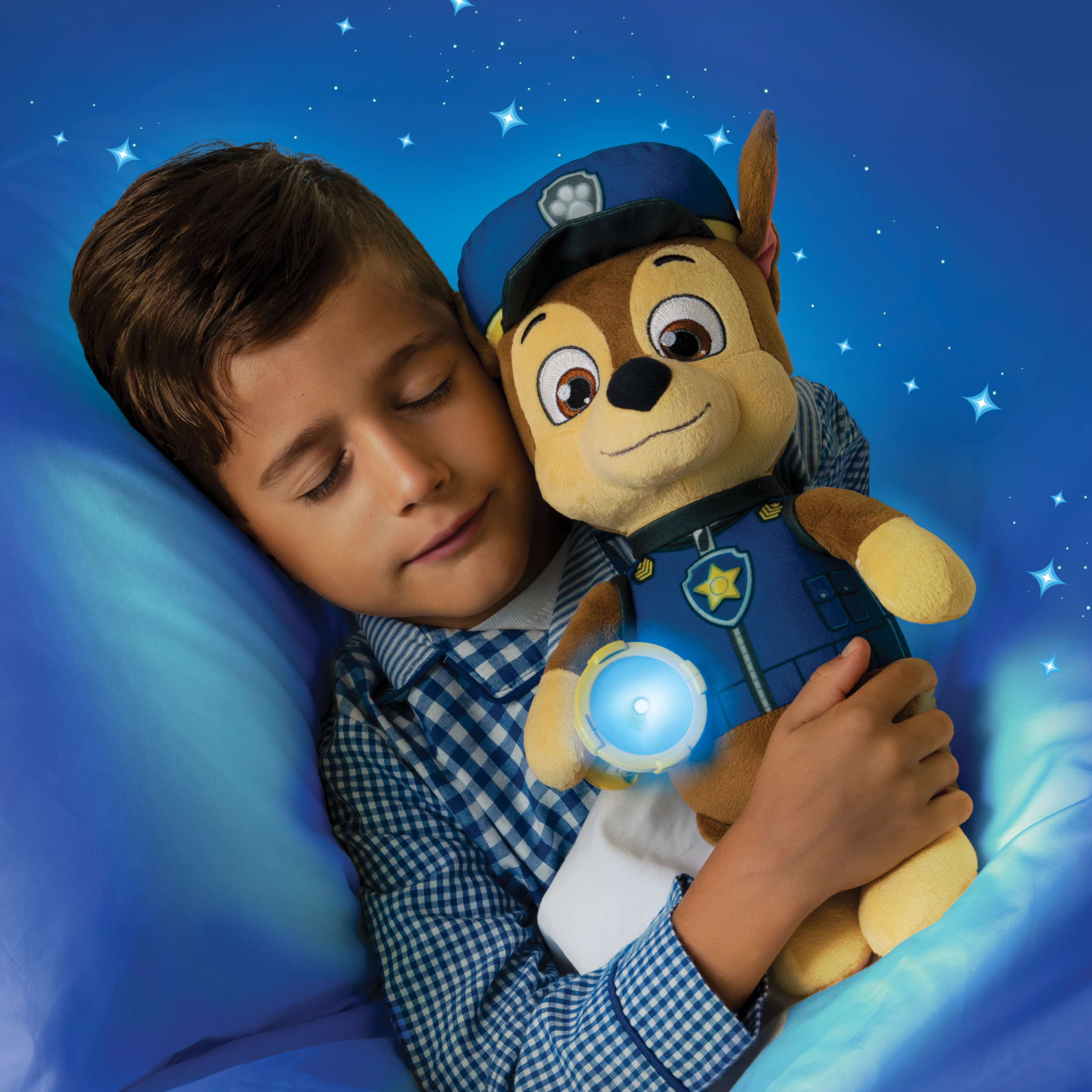 Ragazzo che abbraccia il peluche di Chase di notte. Stelle sullo sfondo. Illuminazione blu.