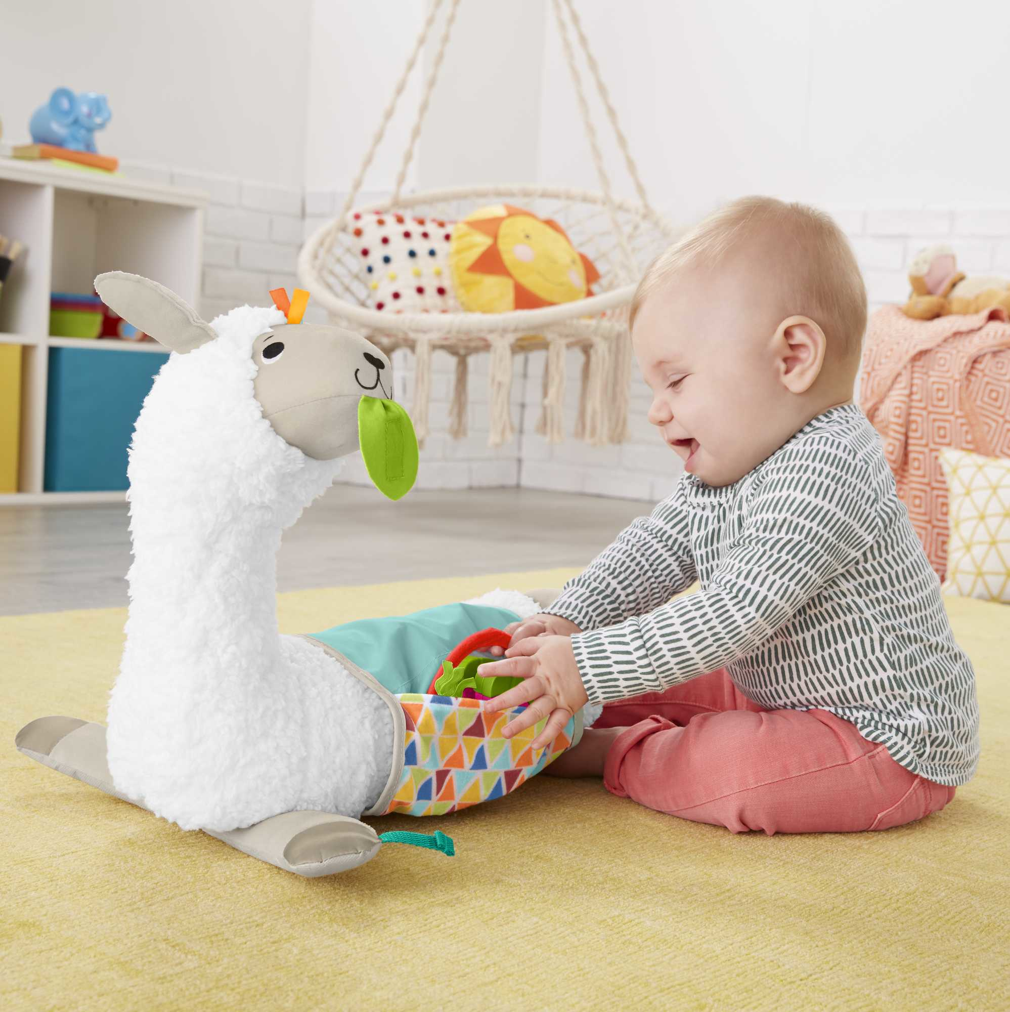 Un bambino gioca con un giocattolo a forma di lama. Un'altalena e altri giocattoli sullo sfondo. Il bambino sorride.