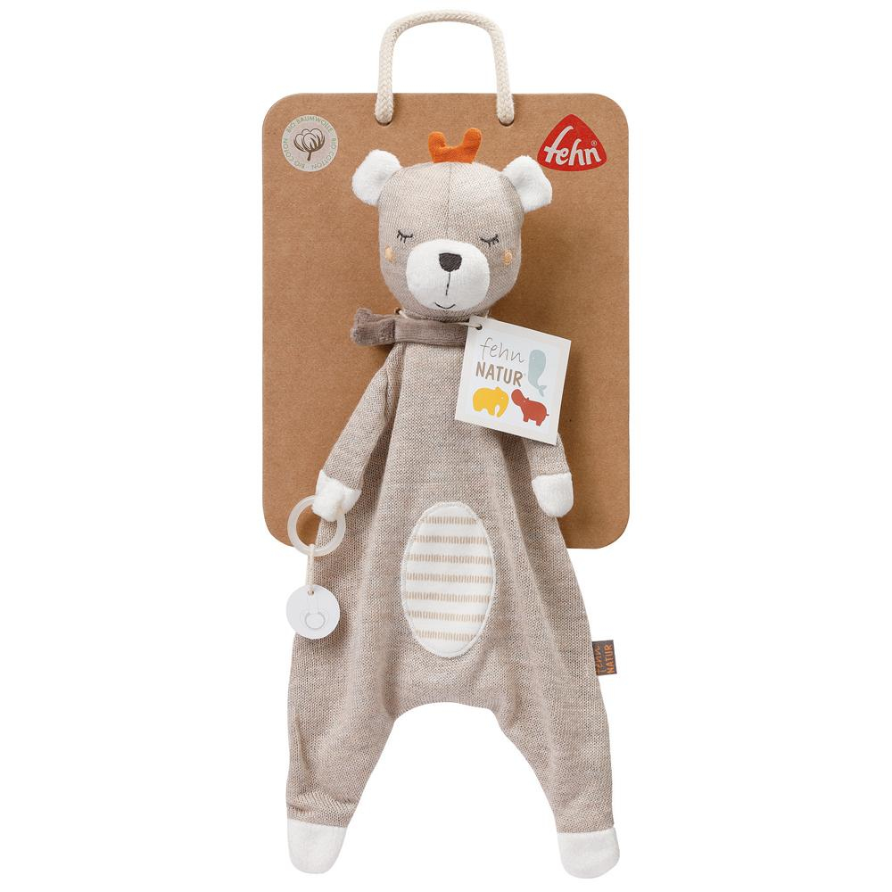 Orsetto di peluche in una confezione regalo. L'orso è beige con una sciarpa e un'etichetta.