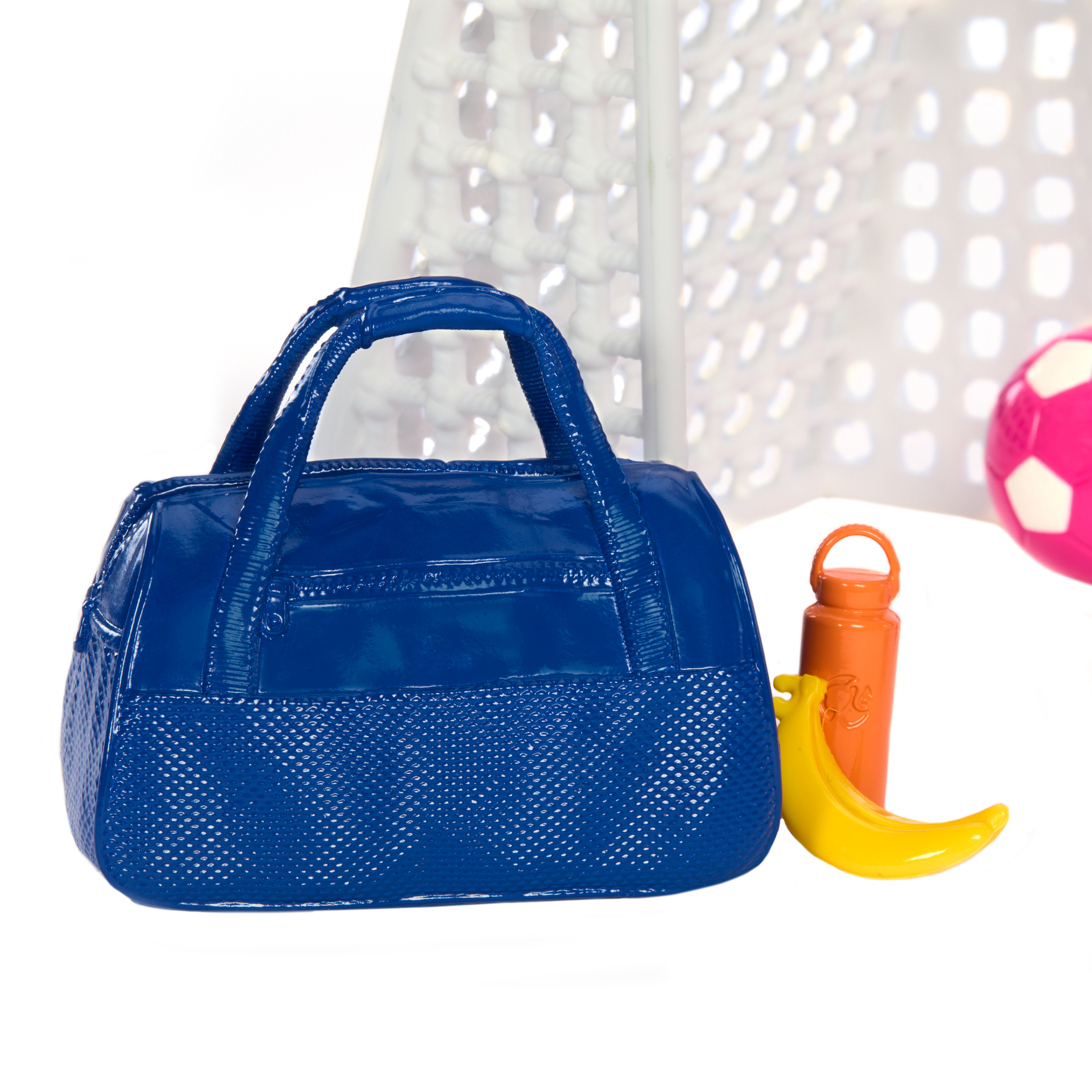 Blaue Sporttasche, orangefarbene Wasserflasche und eine gelbe Banane neben dem Fußballtor.