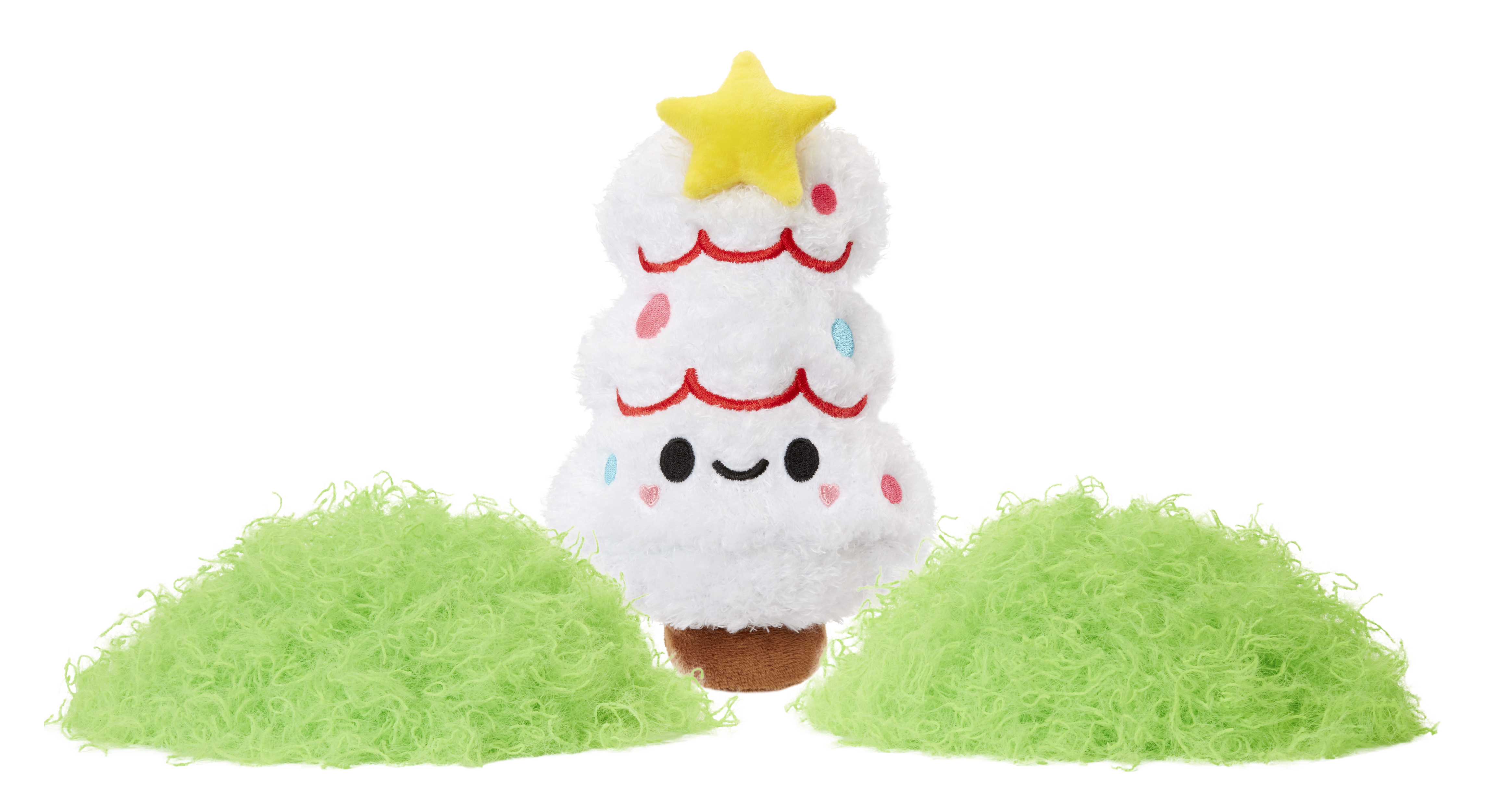 Biała pluszowa zabawka choinka z gwiazdą, otoczona dwoma zielonymi, rozmytymi kształtami.