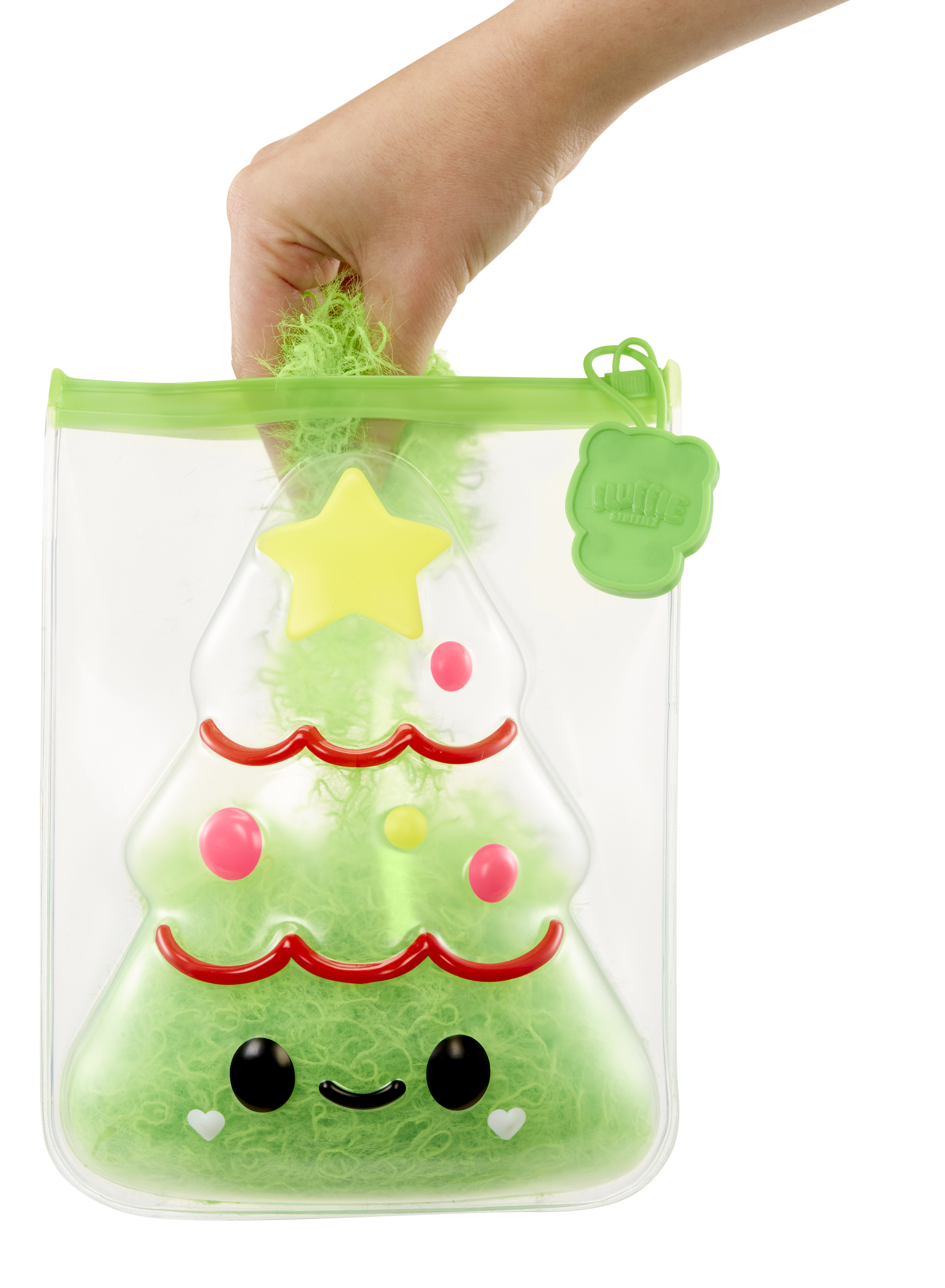 Ręka trzymająca przezroczystą plastikową torbę wypełnioną zielonym puchem w kształcie choinki.