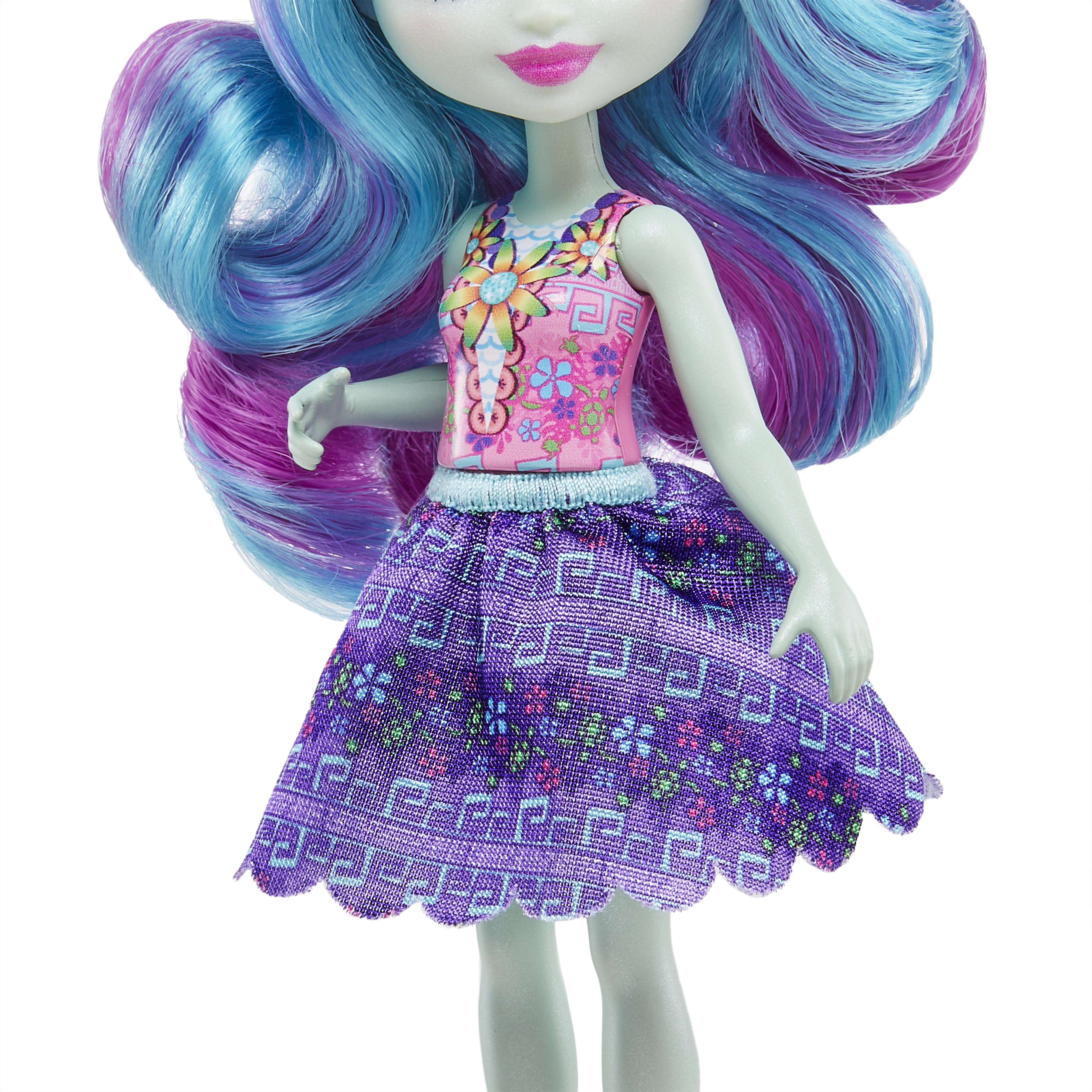 Lalka z niebiesko-fioletowymi włosami, w różowym topie w kwiaty i fioletowej spódnicy.