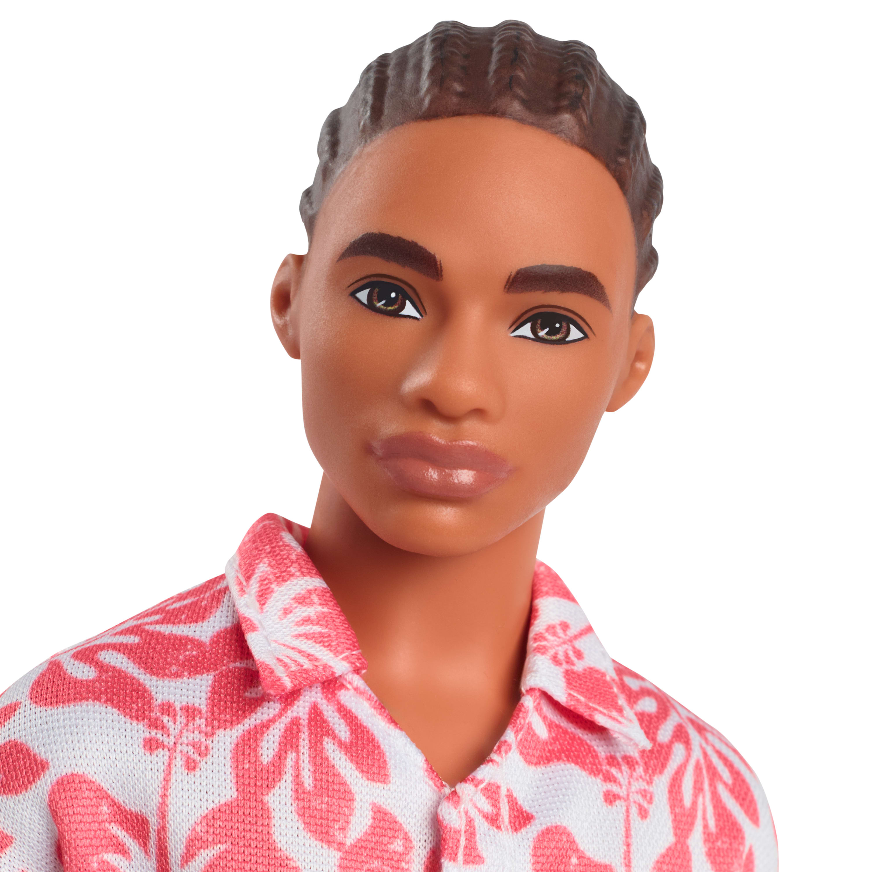 Primer plano de la cara de la muñeca Ken, cabello castaño, con camisa floral rosa y blanca.