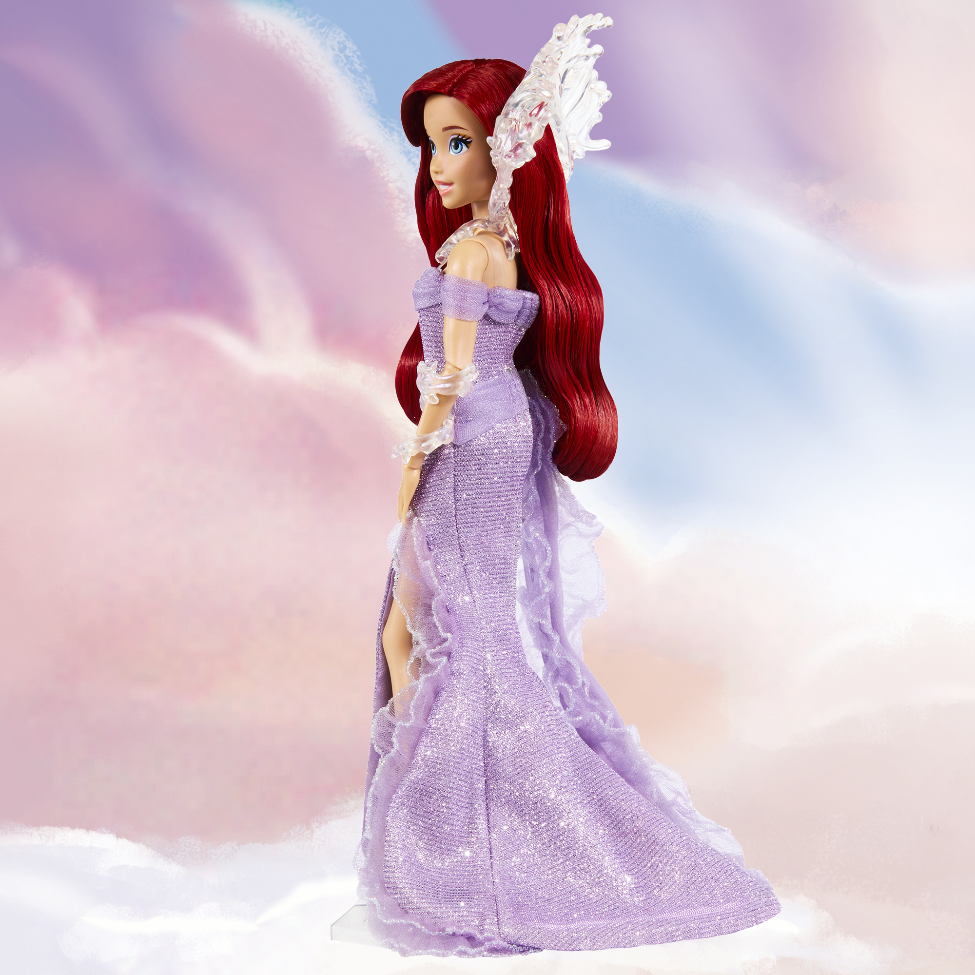 Ariel-Puppe in einem lila Kleid mit roten Haaren, mit einem wolkigen Hintergrund.