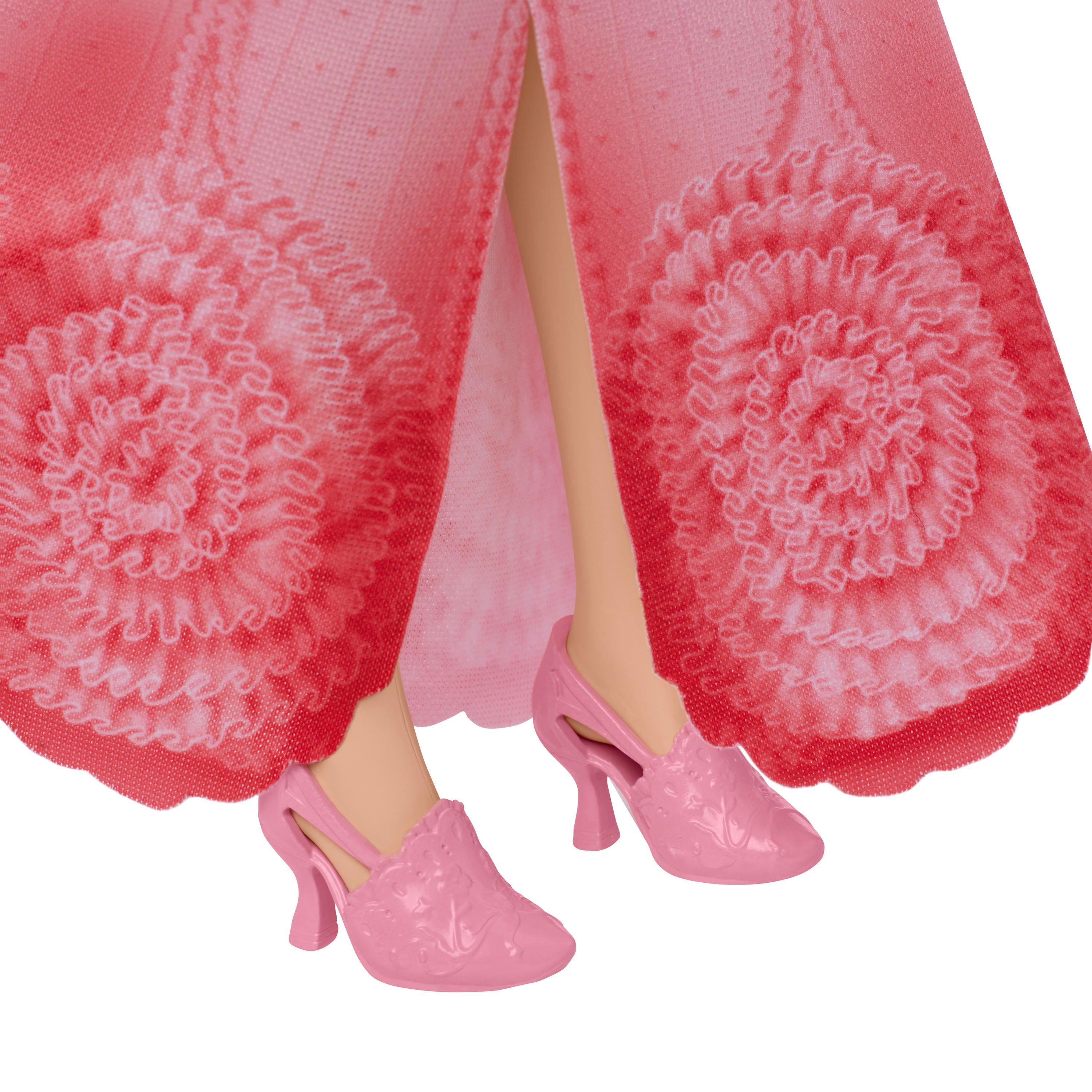 Nahaufnahme der Füße einer Puppe in rosa Schuhen, Teil eines rosa Kleides mit floralen Rüschen.
