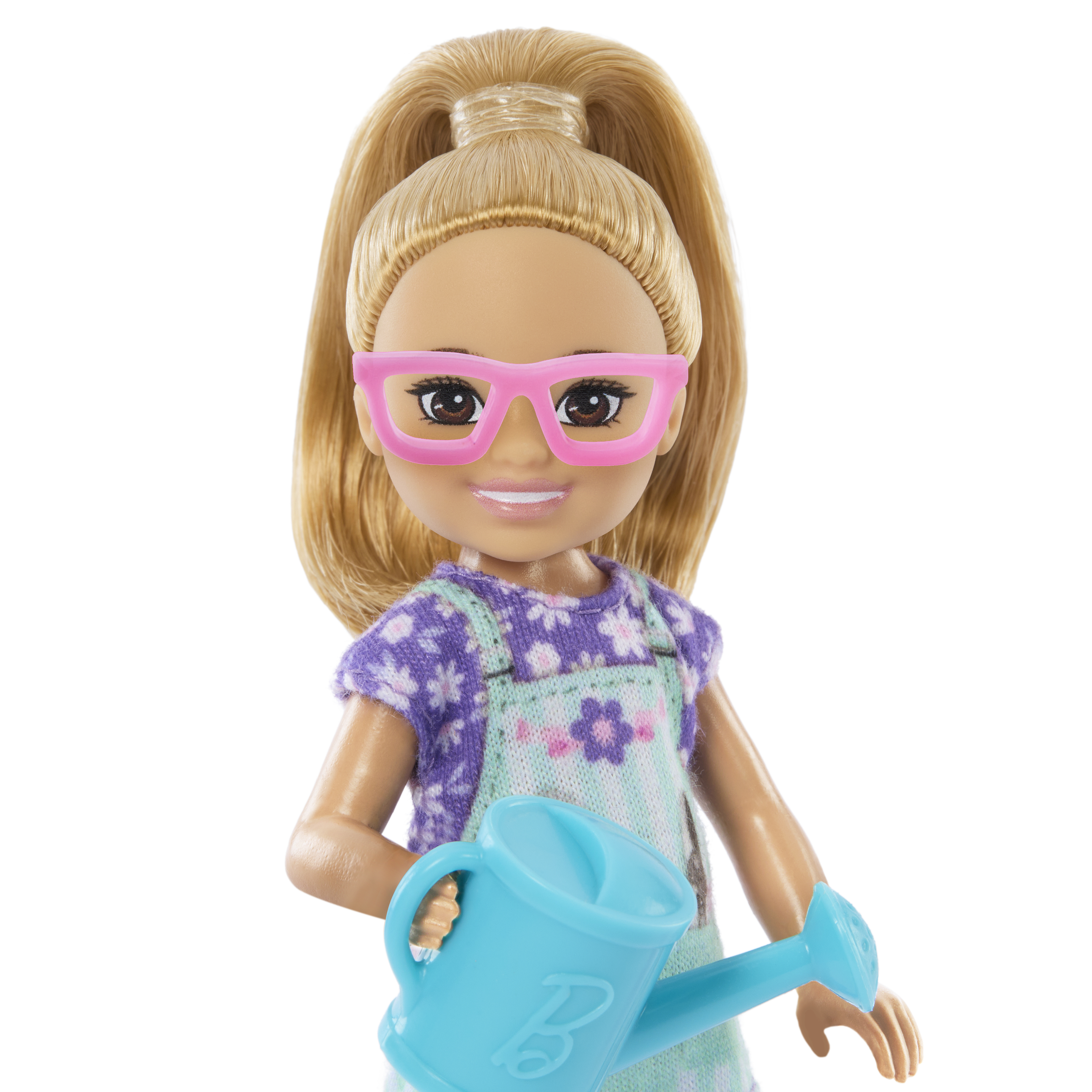 Eine Puppe mit Pferdeschwanz trägt eine rosa Brille und hält eine blaue Gießkanne, lila Outfit.