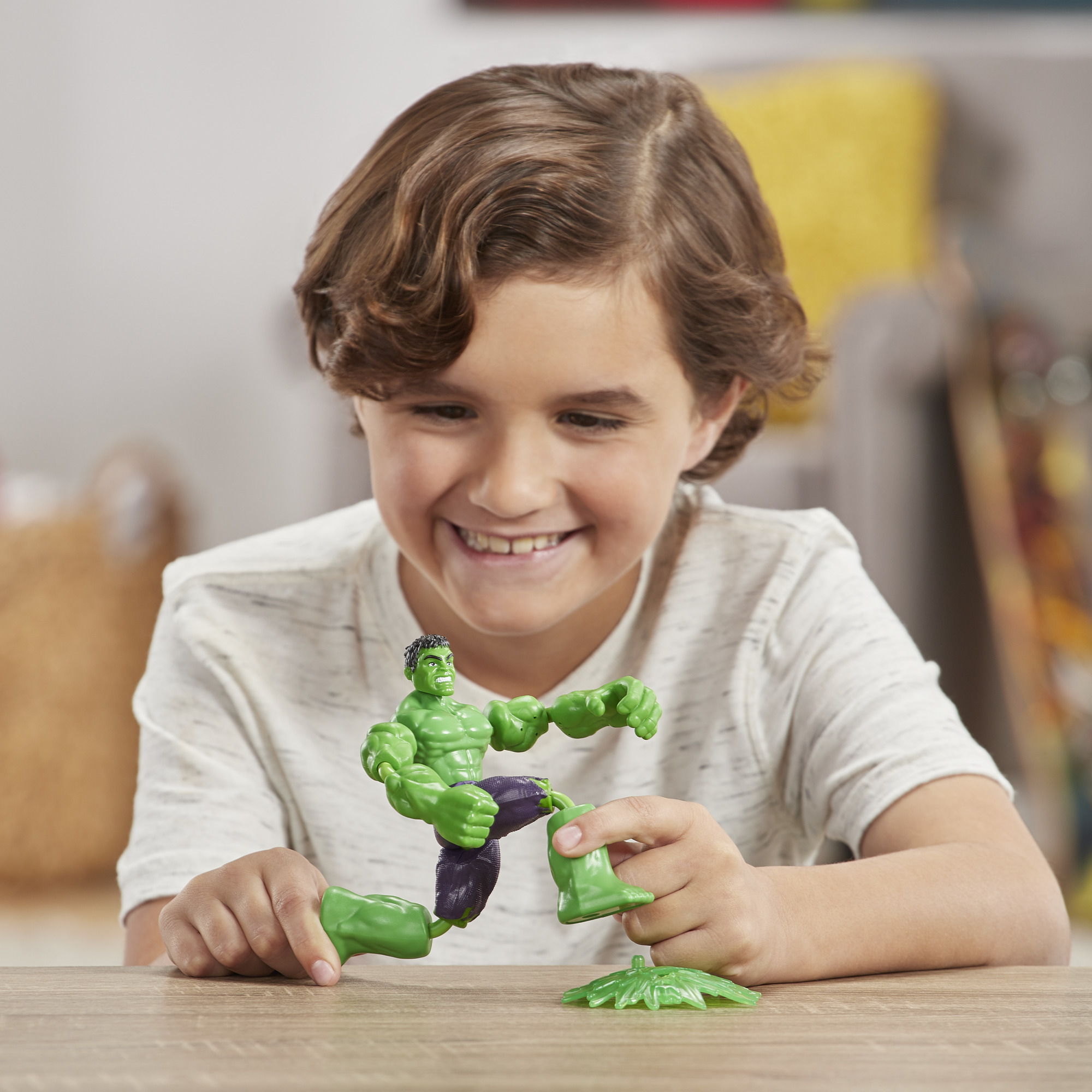 Ragazzo che gioca con Hulk, assembla la figura su un tavolo.