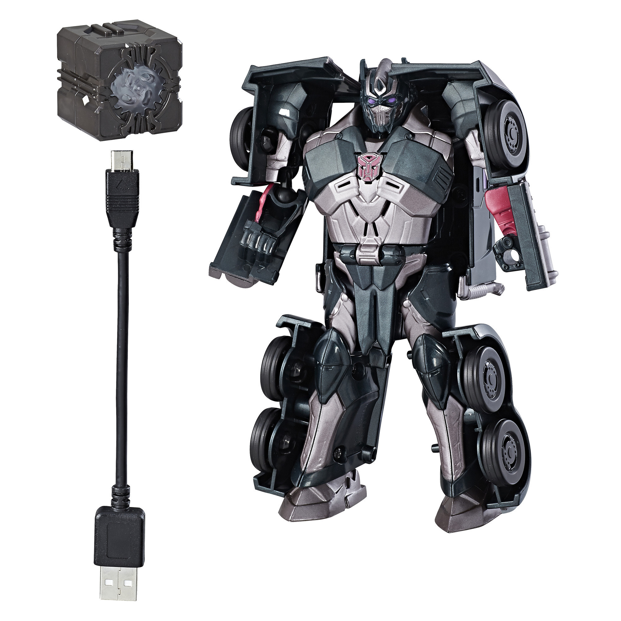 Un giocattolo Transformer grigio con accessori. Include un cubo e un cavo USB. Il Transformer è in modalità robot.