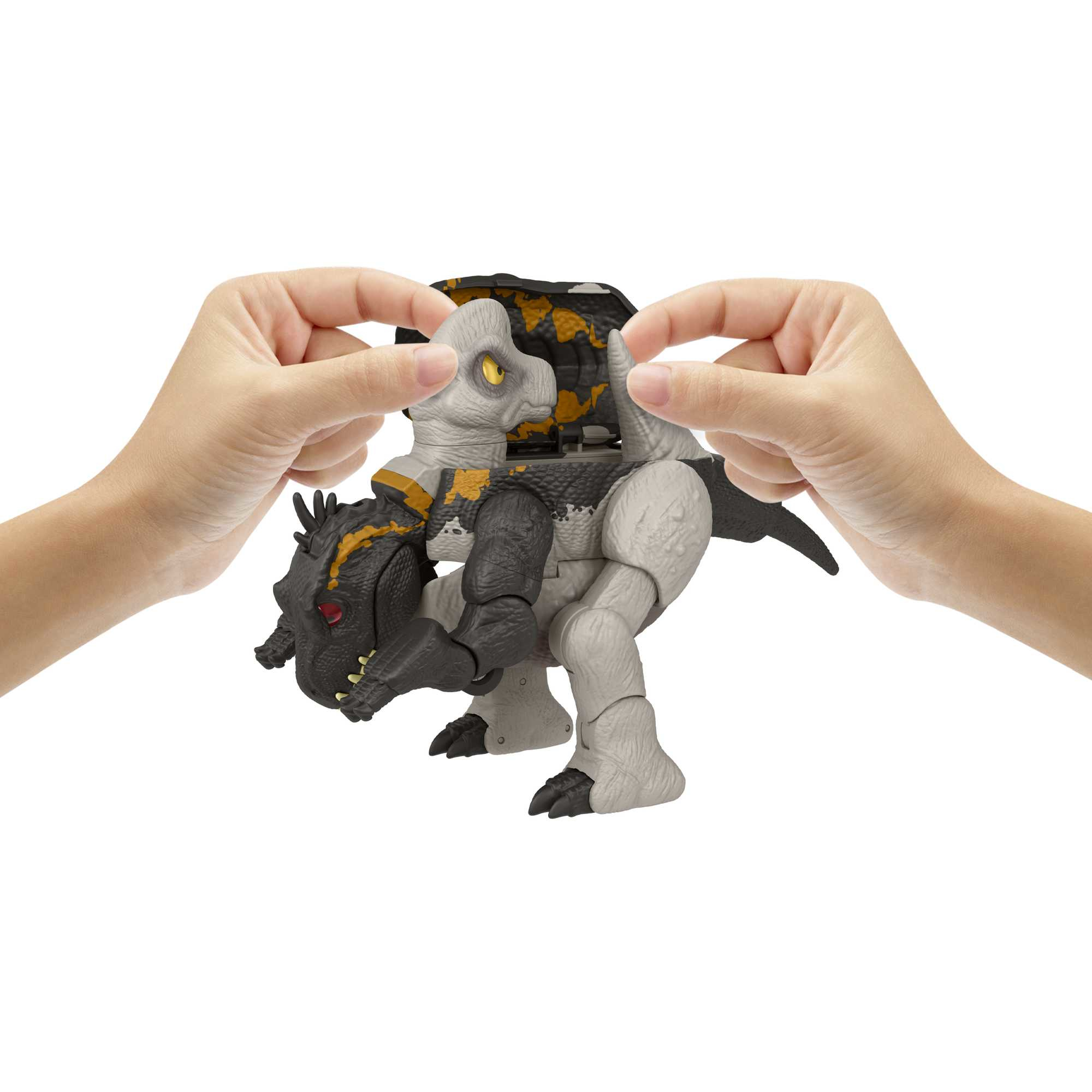 Hände, die ein Dinosaurier-Spielzeug zusammensetzen. Das Spielzeug ist eine Mischung aus Schwarz, Weiß und Gelb.