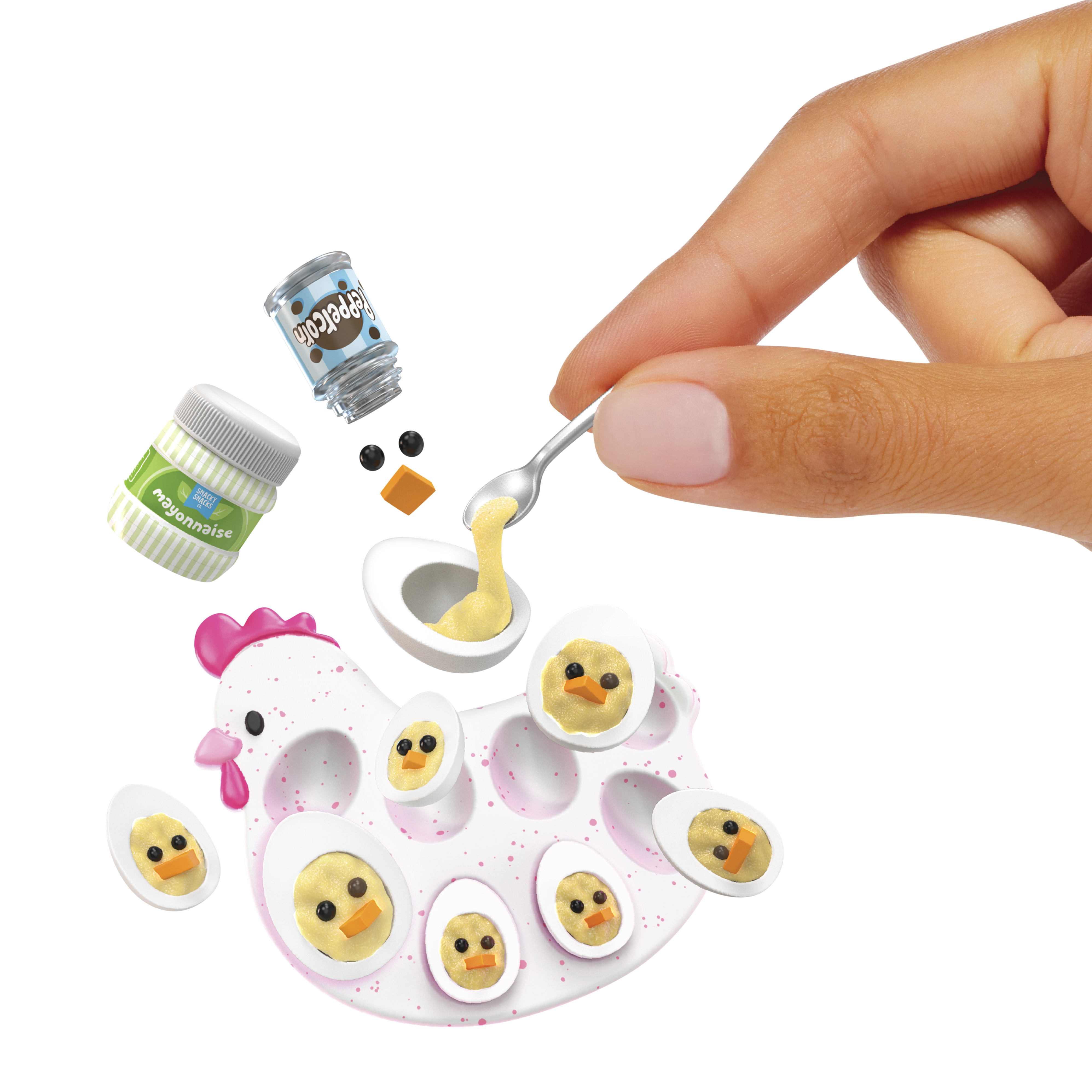 Ręka przygotowuje jajka z przyprawami i kształtami jajek. Białe tło.