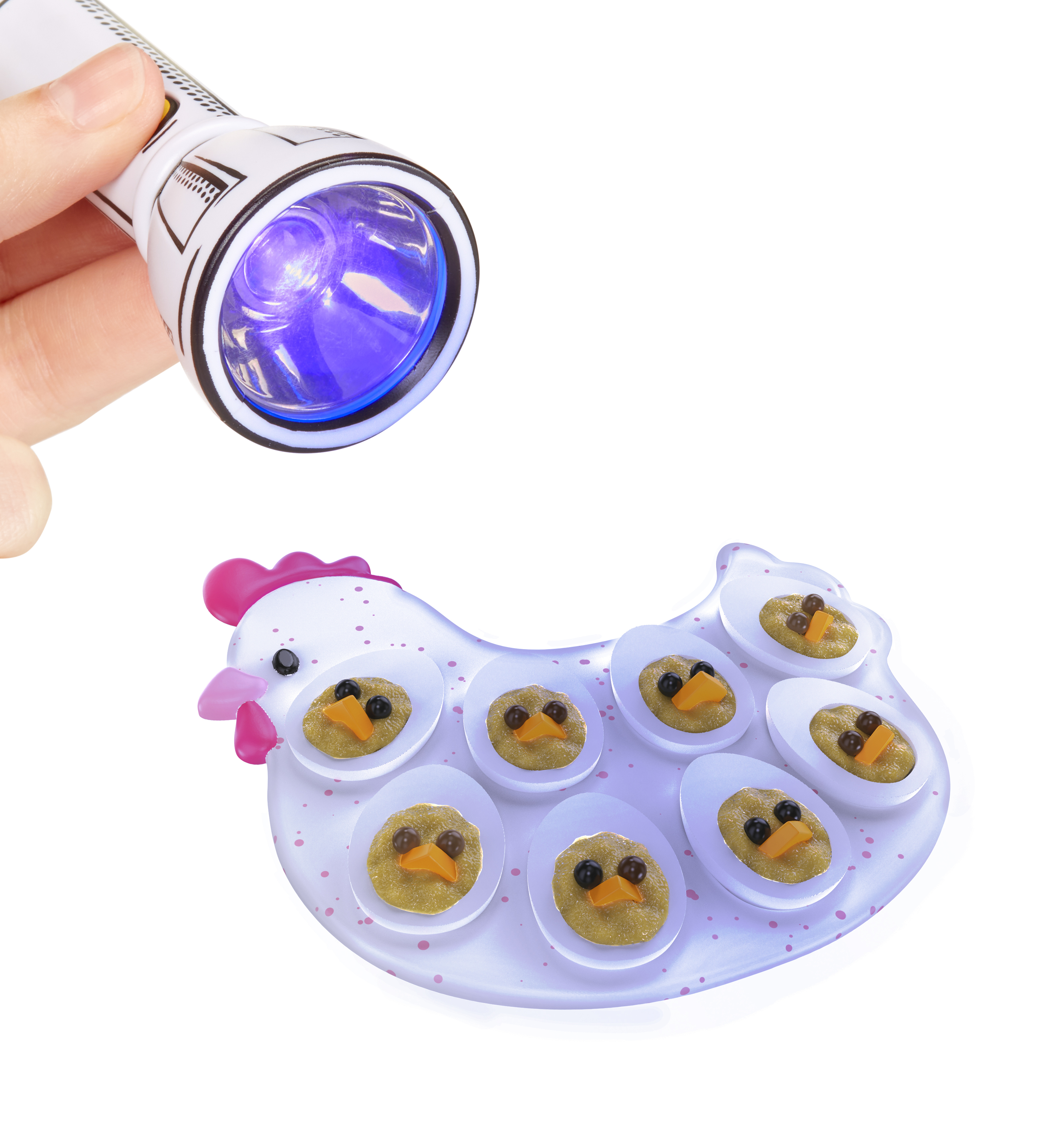 Ręka trzymająca latarkę świecącą na tacę z jajkami w kształcie kurczaka.