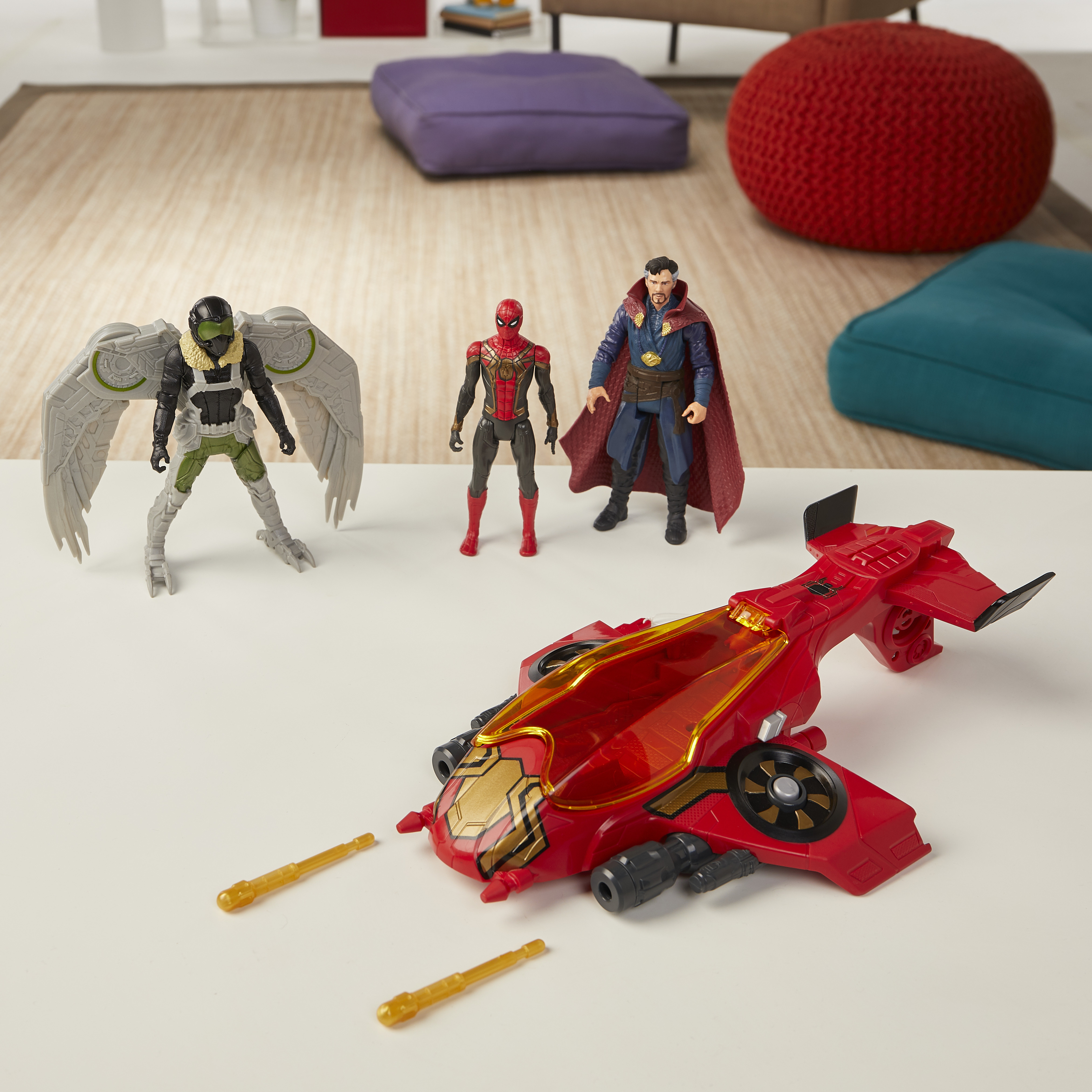 Figure di Vulture, Spider-Man, Doctor Strange e un veicolo rosso sono su un tavolo bianco al chiuso.