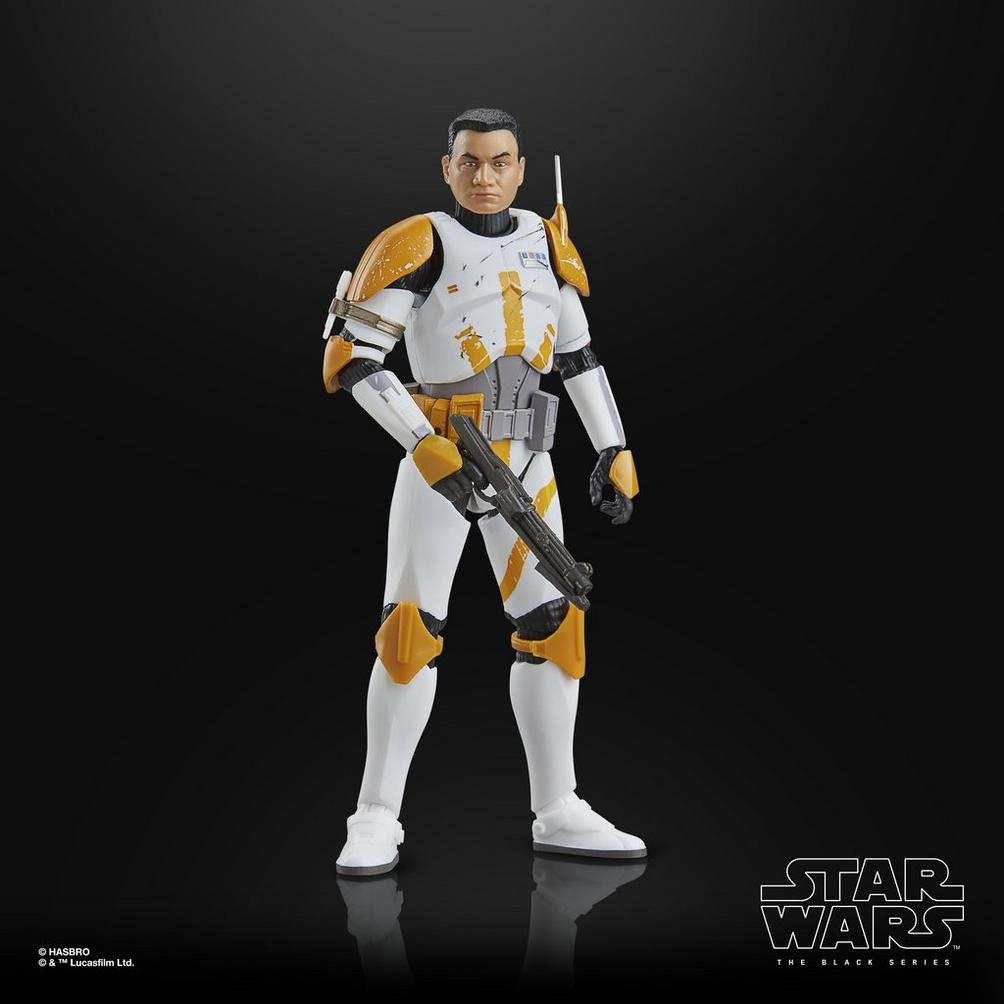 Siyah bir arka plan üzerinde, beyaz ve turuncu zırhlı, blaster tutan bir Star Wars Clone Trooper aksiyon figürü.