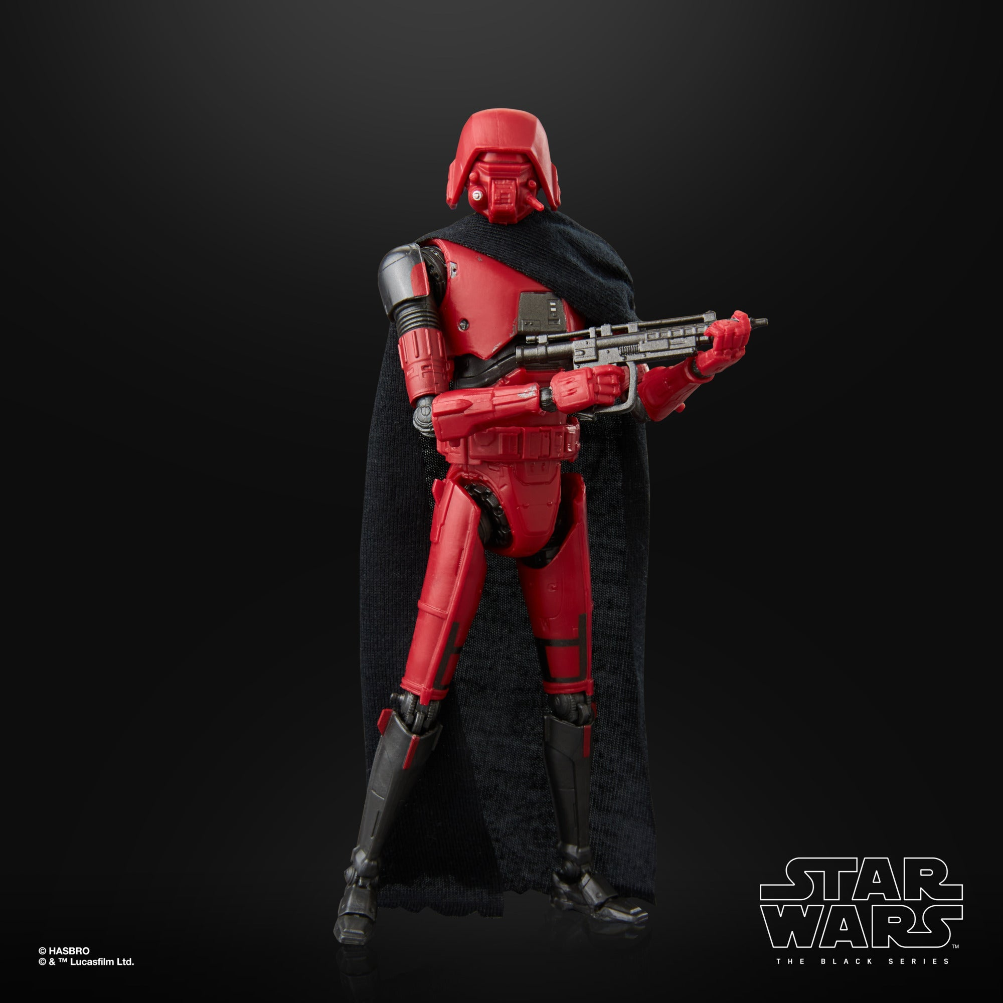 Eine rot gepanzerte Star Wars Figur mit schwarzem Umhang, die ein Gewehr vor schwarzem Hintergrund hält.