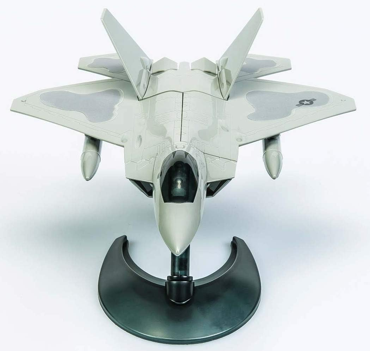 Model F-22 Raptor na podstawce, widok z góry. Jest szary, z czarną podstawą i białym tłem.