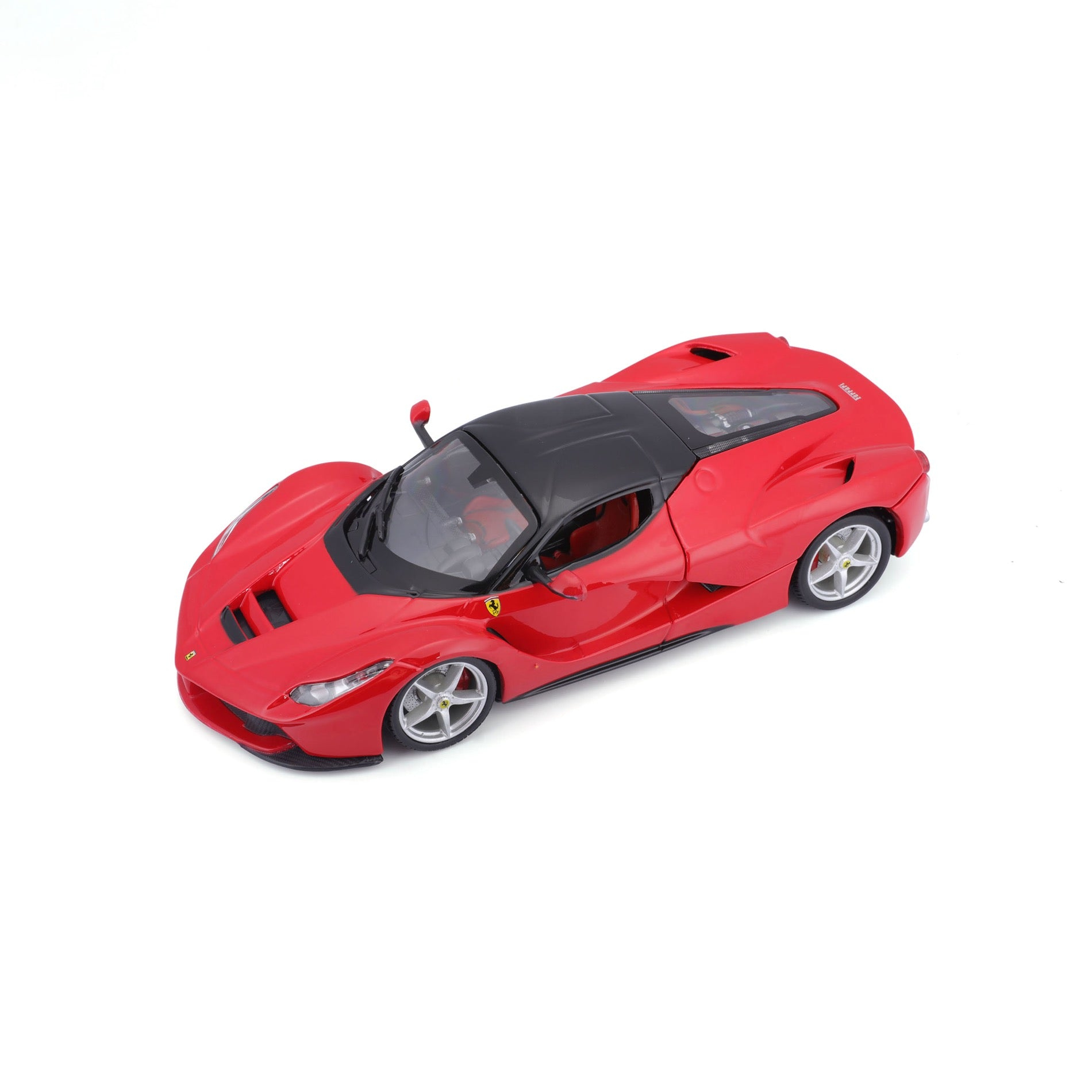 Czerwony samochodzik Ferrari LaFerrari. Samochód stoi na białej powierzchni. Ma czarny dach.