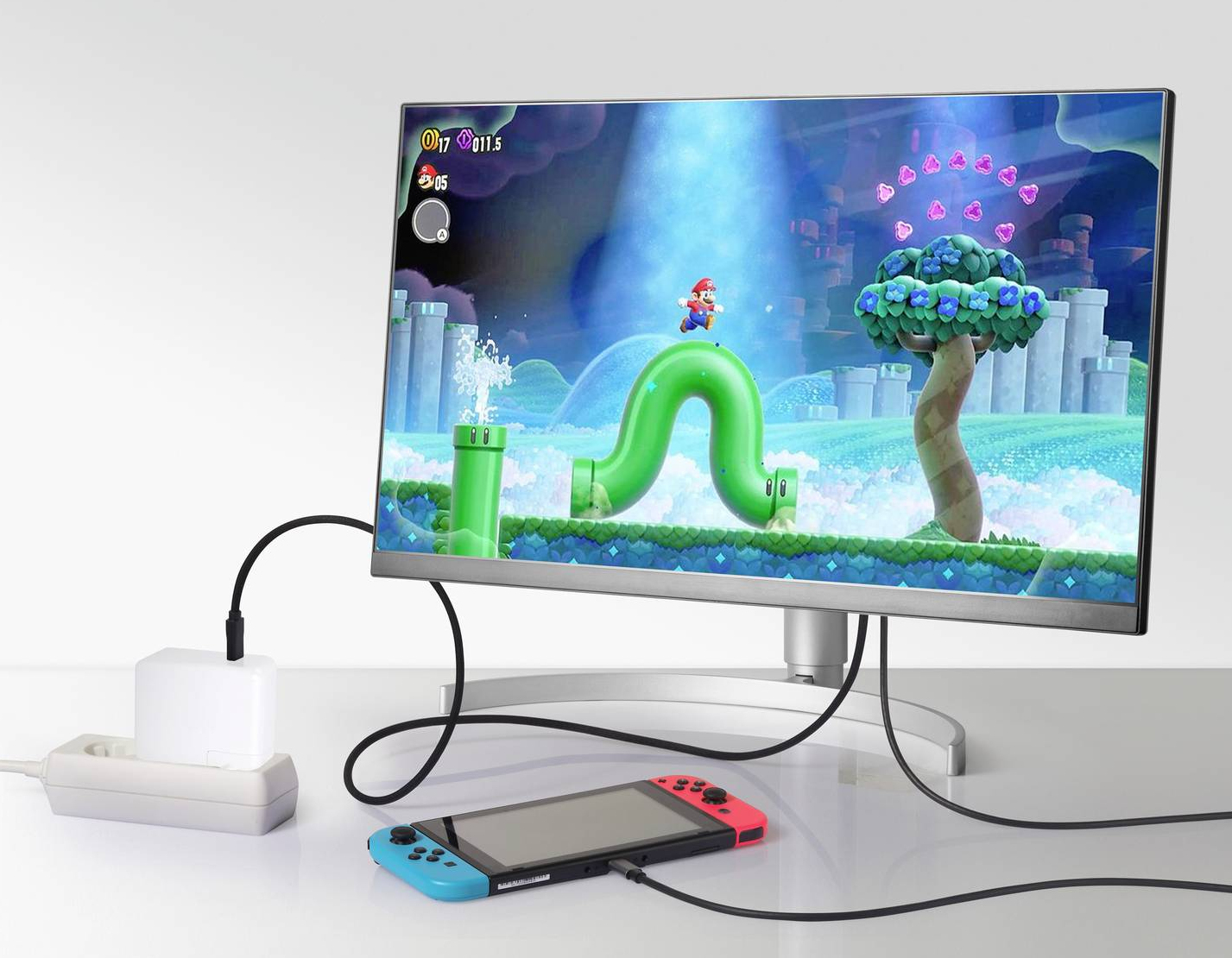 Gioco su un monitor, con una console e un alimentatore collegati.