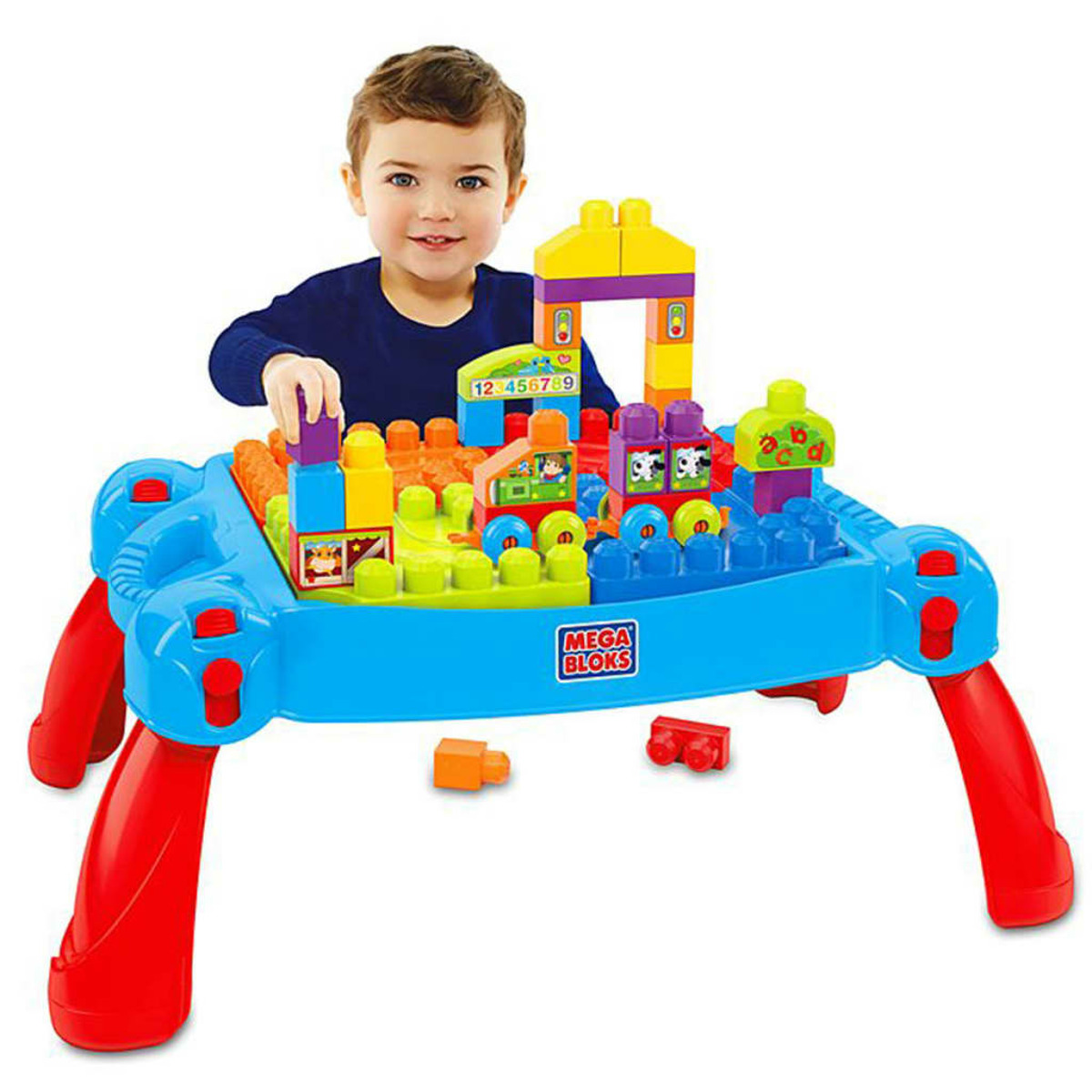 Mały chłopiec bawiący się przy niebieskim stole Mega Bloks z klockami.