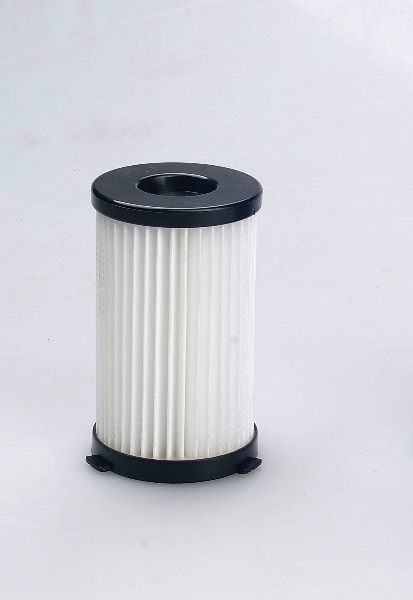 Filtro per aspirapolvere cilindrico bianco con parte superiore e inferiore nere. Sfondo bianco.