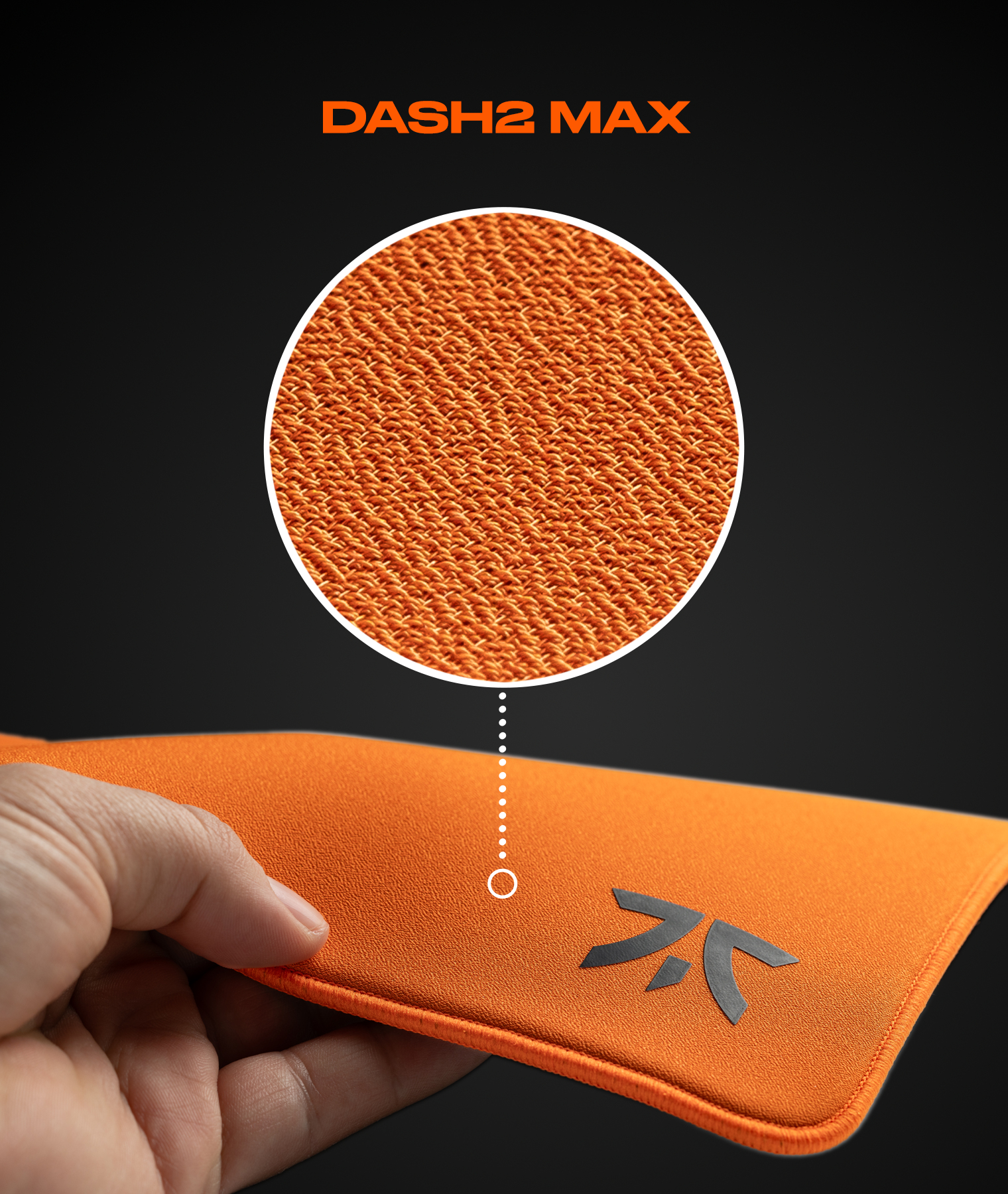 Dłoń trzymająca pomarańczową podkładkę pod mysz. Powierzchnia powiększona. Tekst: DASH2 MAX, logo FNATIC.