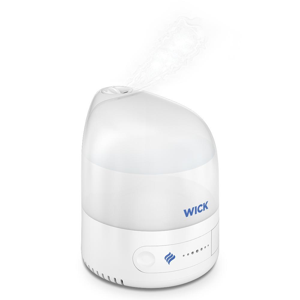 Umidificatore bianco con logo "WICK". Il vapore esce dall'alto. Sfondo bianco.