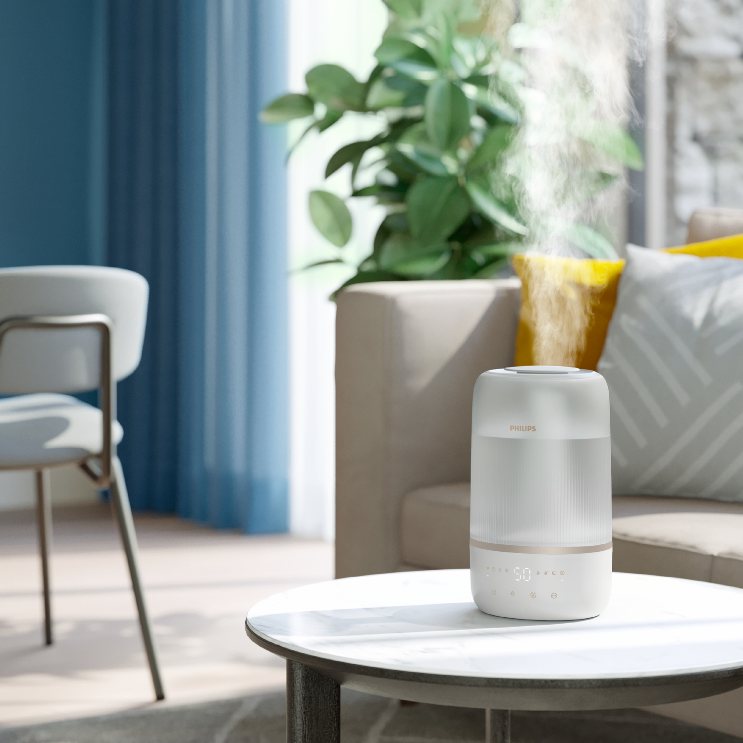 Biały nawilżacz na stole oraz ustawienie salonu z kanapą i osobą.