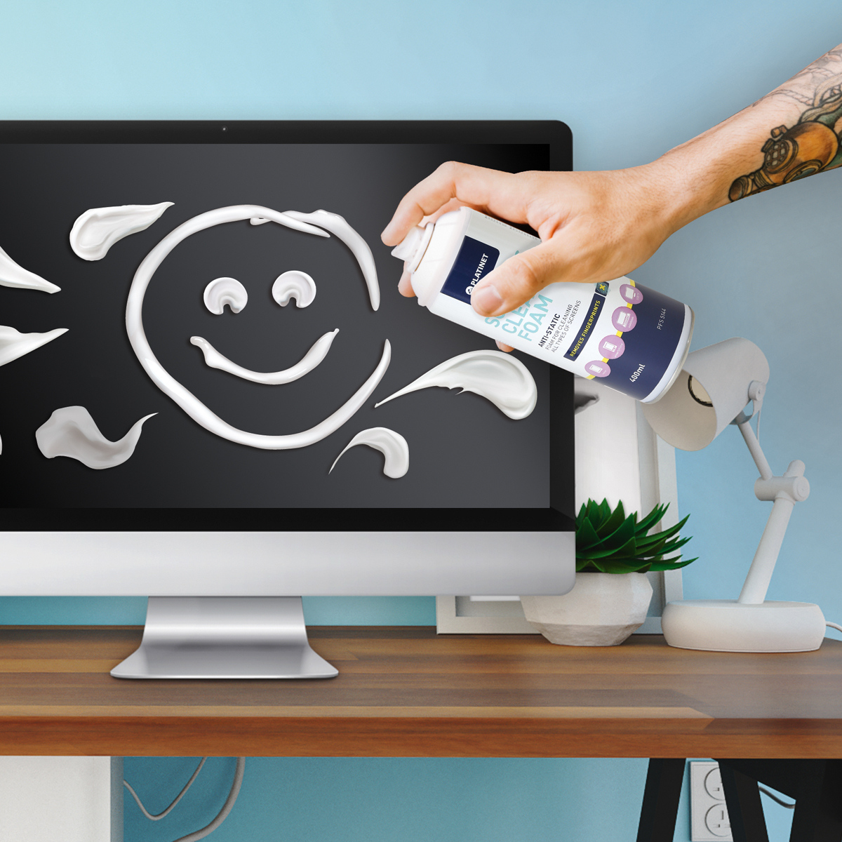 Una persona che spruzza schiuma su uno schermo di computer con una faccia sorridente disegnata.