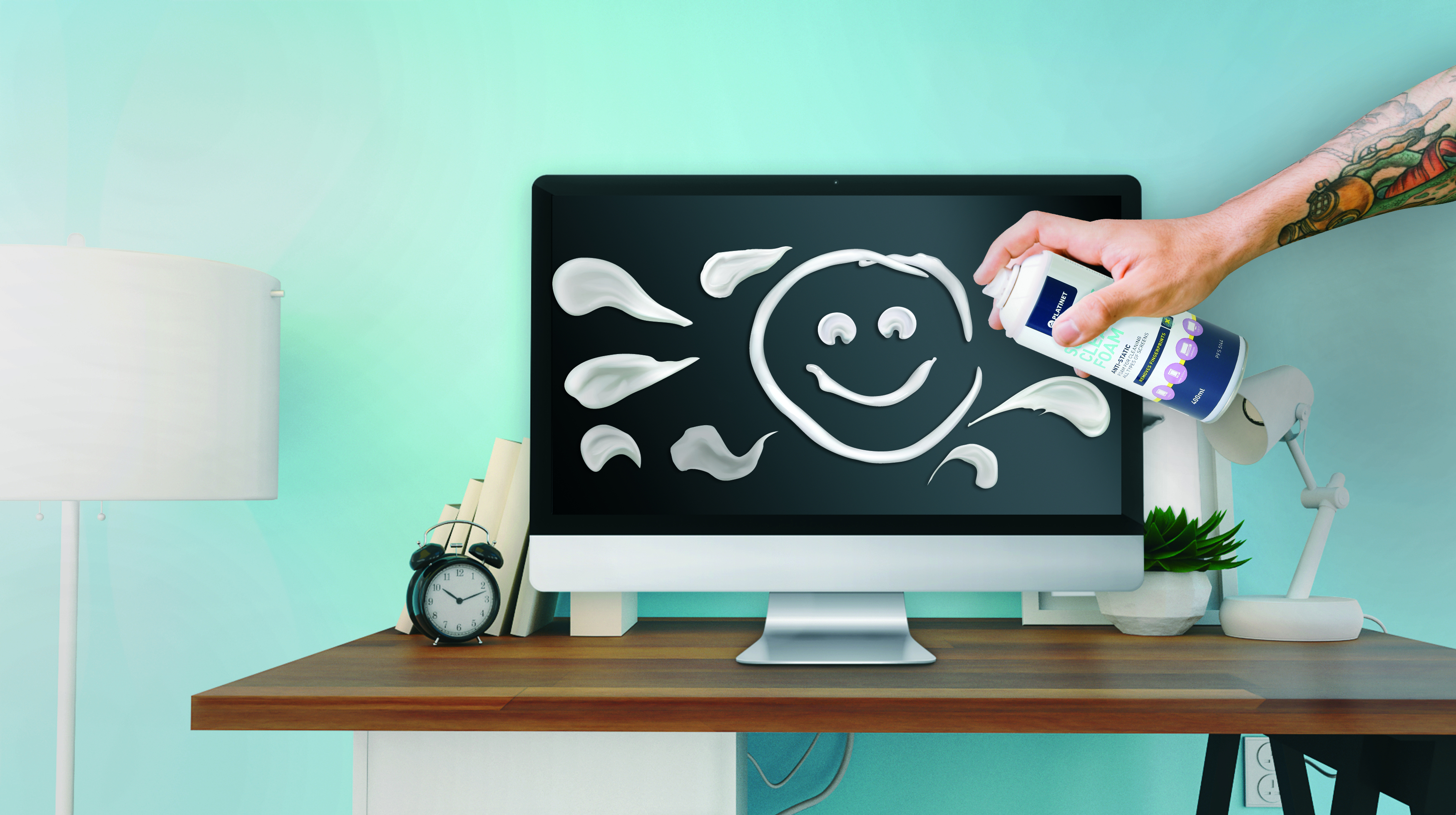 Una mano spruzza schiuma bianca su uno schermo di computer per creare una faccina sorridente.