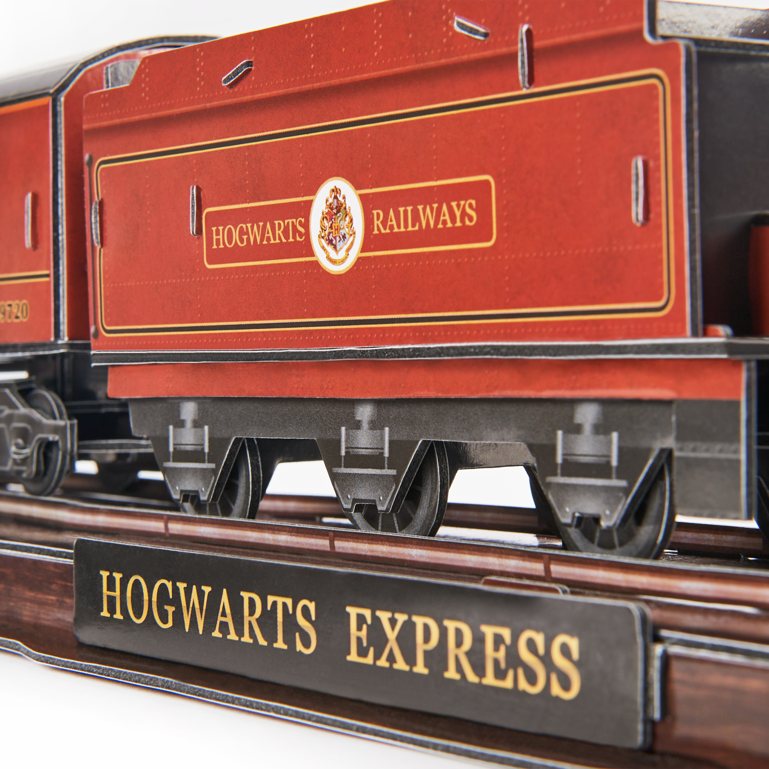 Model pociągu przedstawia napis „Hogwarts Express” na czarnym znaku, z napisem „Hogwarts Railways” z boku.