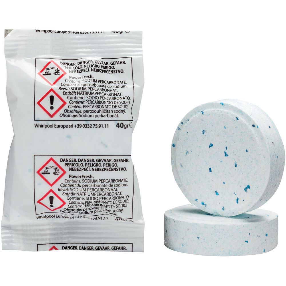 Zbliżenie dwóch tabletek do czyszczenia pralki i opakowania z ostrzeżeniami.