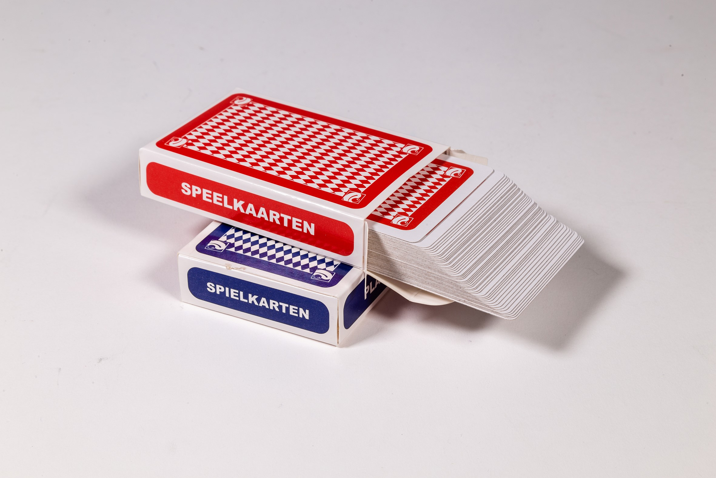 Deux jeux de cartes dans des boîtes. Un rouge, un bleu. Chacun a 'SPEELKAARTEN'.
