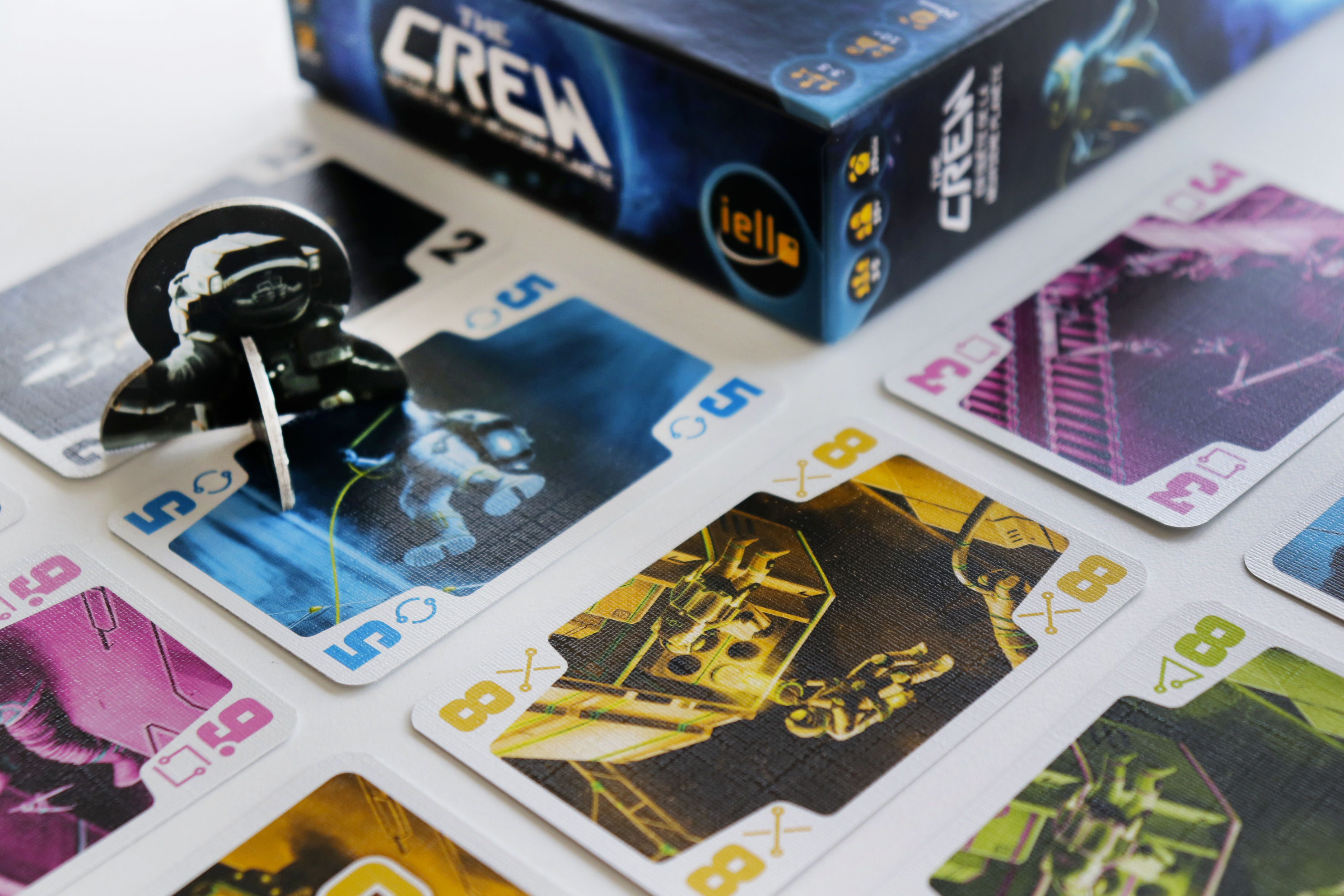 Karty i pudełko gry planszowej z ilustracjami astronautów i motywem kosmicznym.