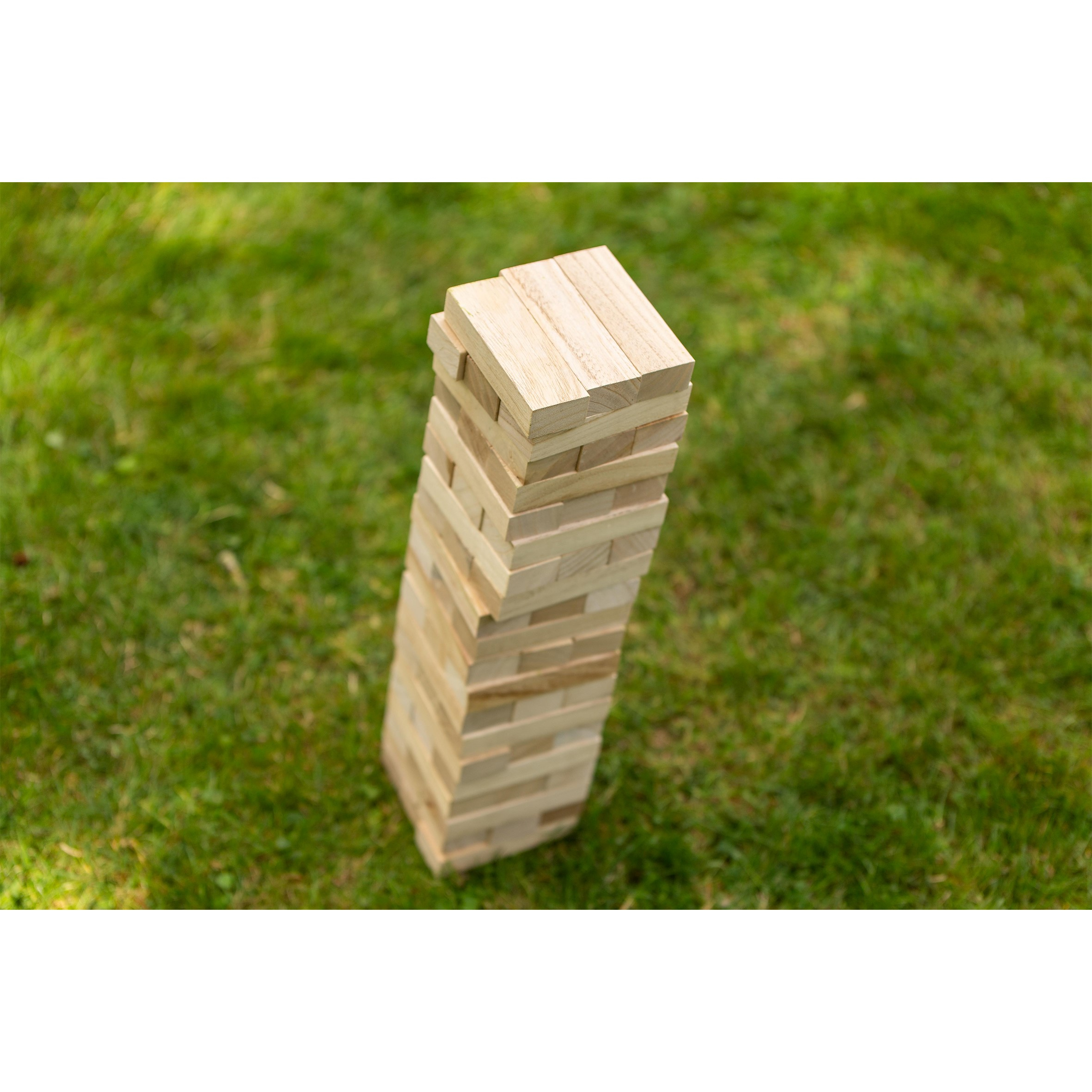 Torre di blocchi di legno sull'erba verde, un gioco simile a Jenga.