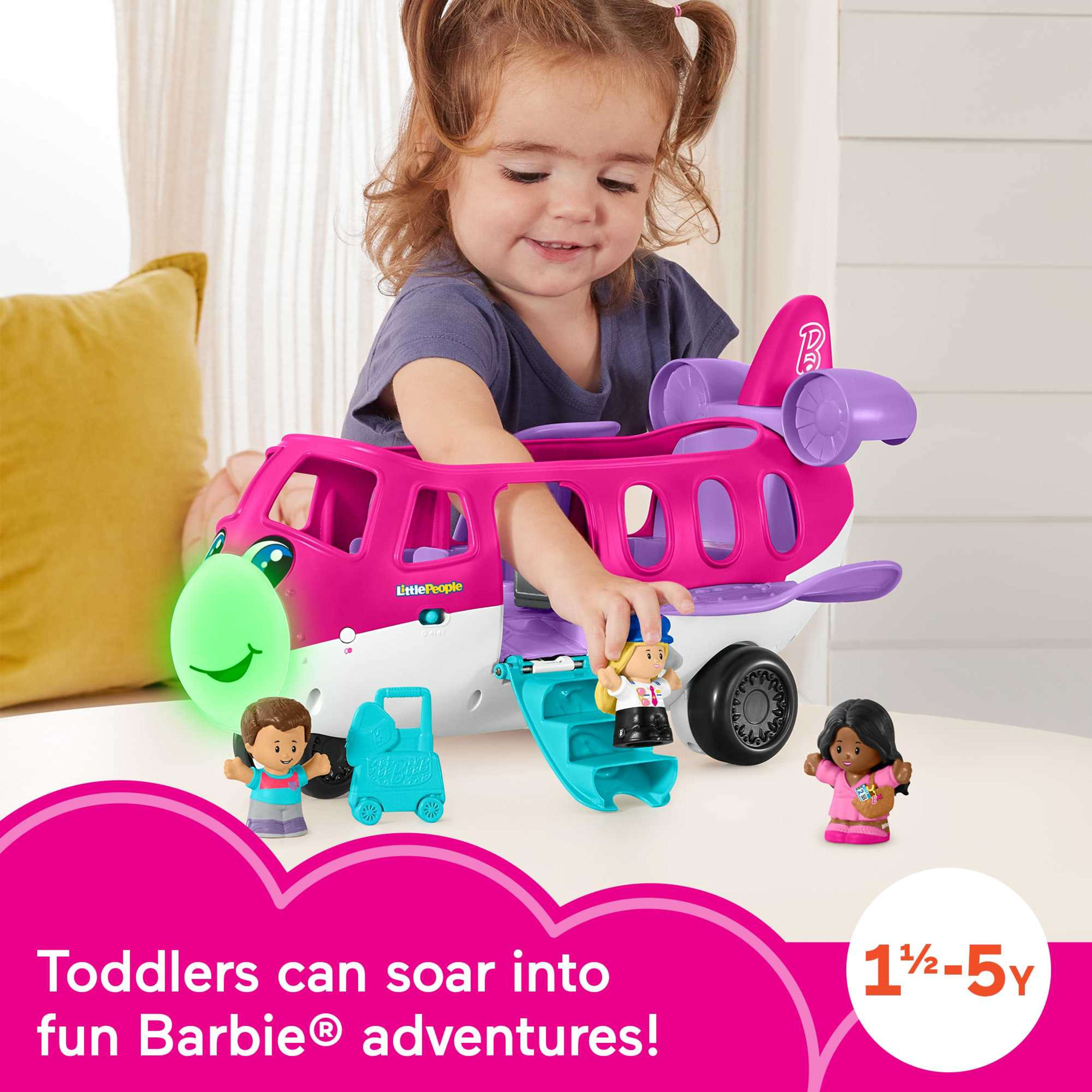 Dziecko bawiące się różowym samolotem z figurkami i wózkiem.