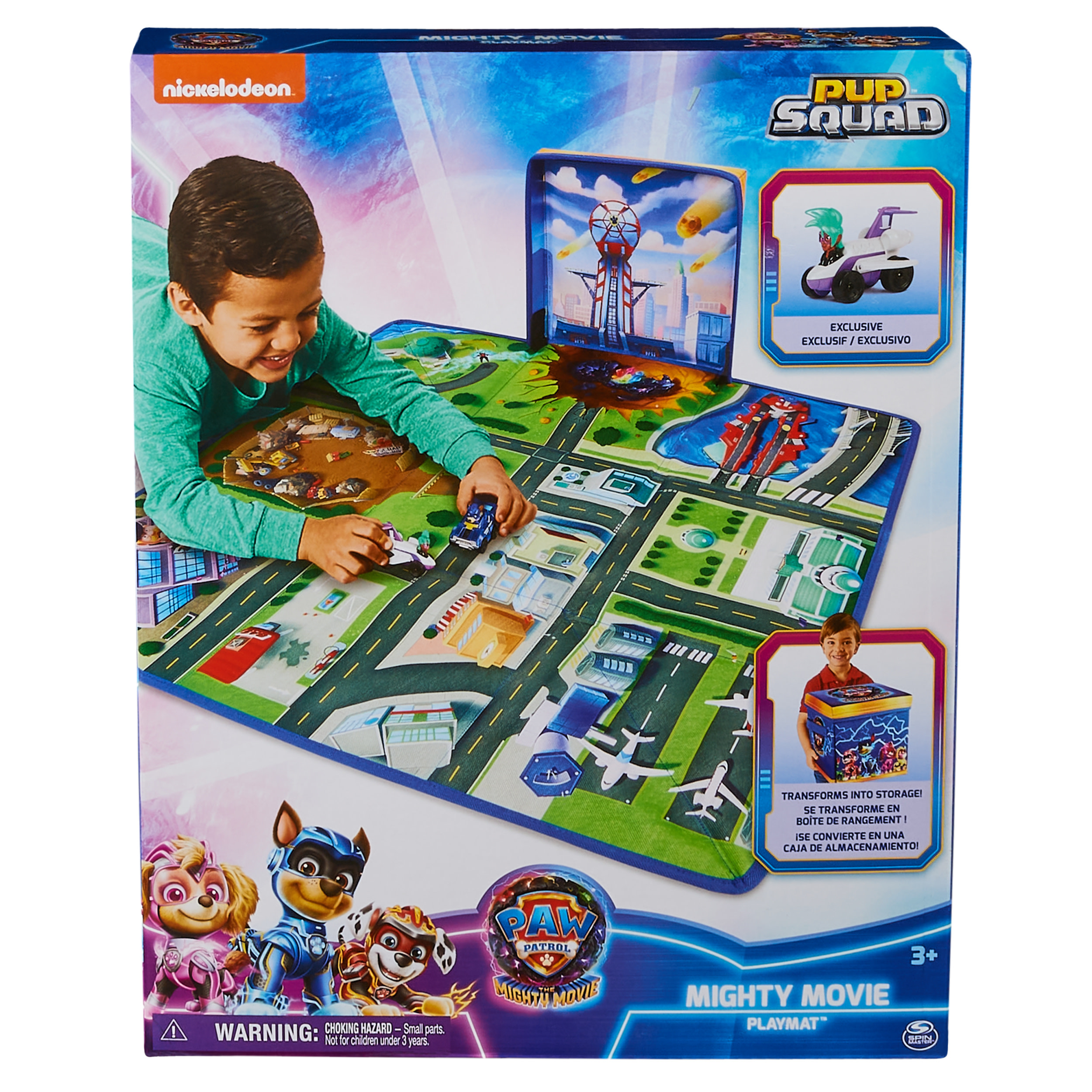 Mały chłopiec bawi się matą do zabawy Paw Patrol Mighty Movie. Pudełko jest w tle ze sceną miejską.