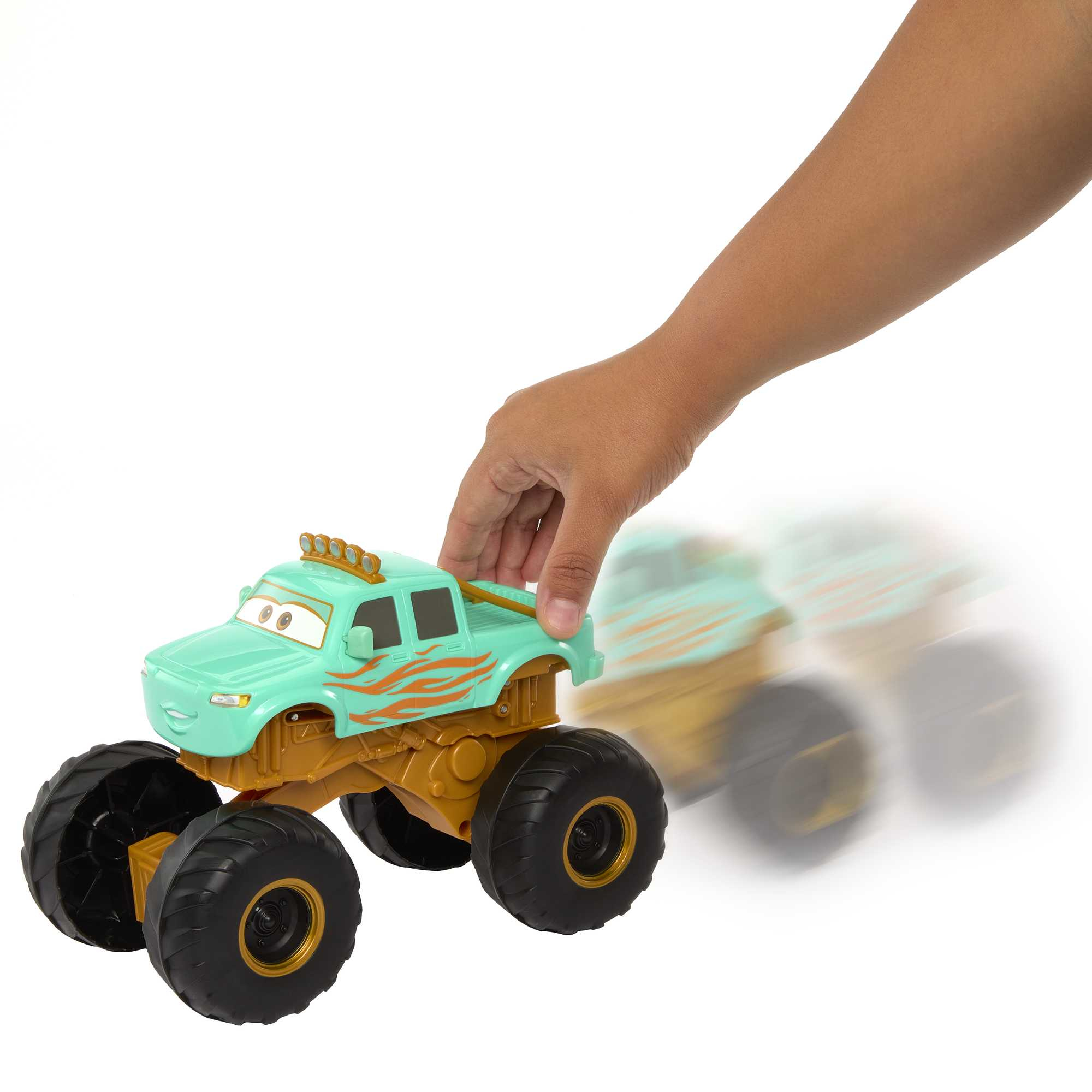 Ręka pchająca zabawkowy monster truck po powierzchni.