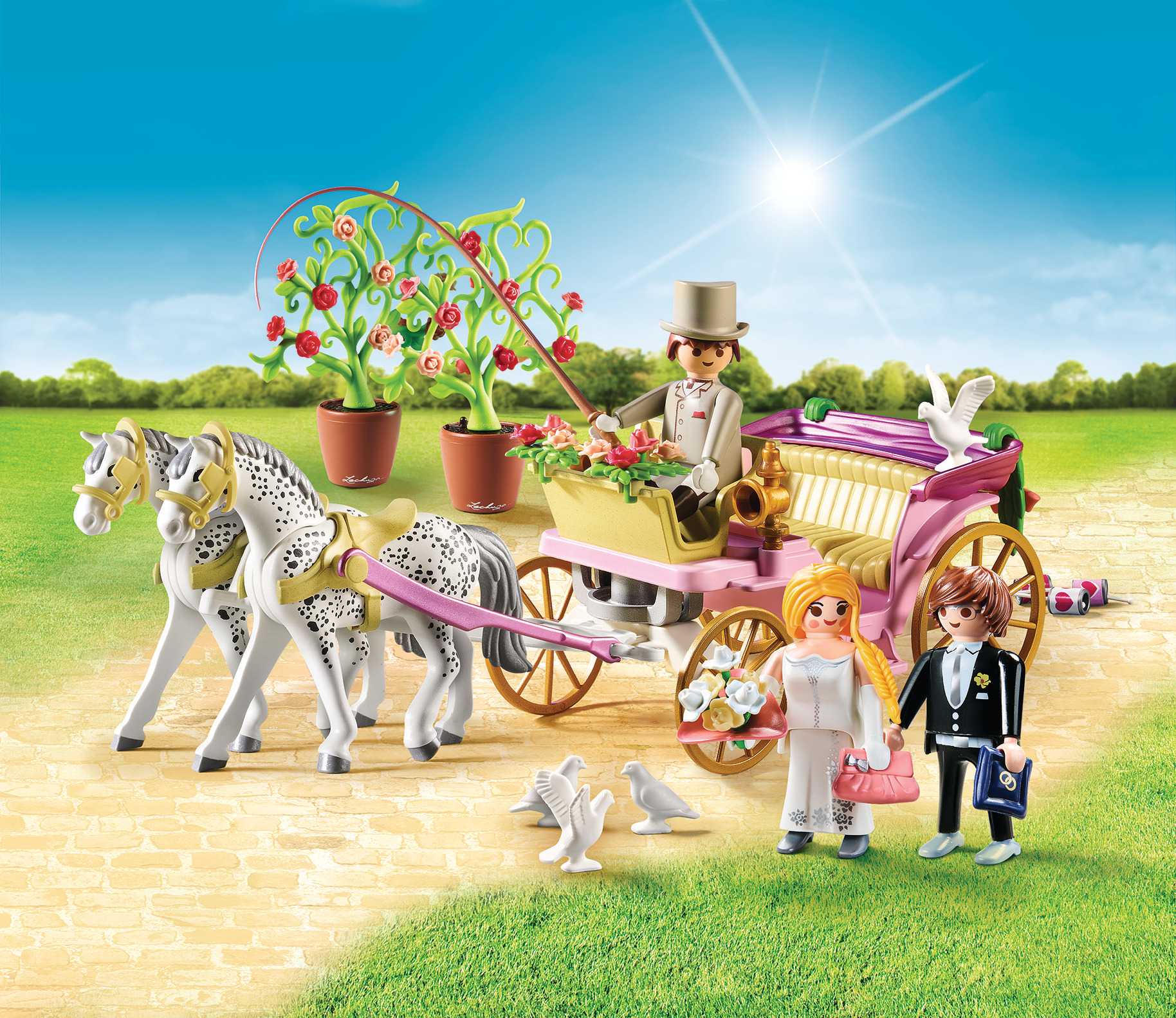 Playmobil-Set. Pferdekutsche mit Braut, Bräutigam und Tauben. Grünes Gras und helle Sonne.
