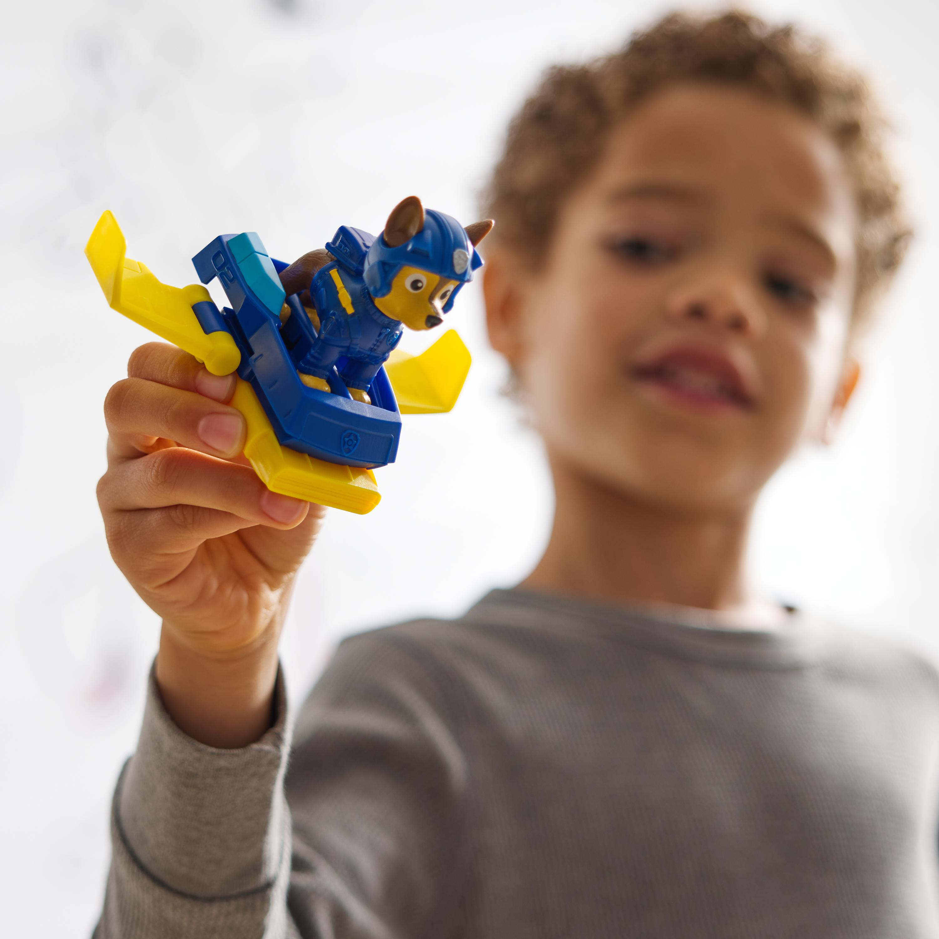 Ein Kind hält ein Paw Patrol Spielzeugflugzeug. Das Spielzeug ist blau und gelb.