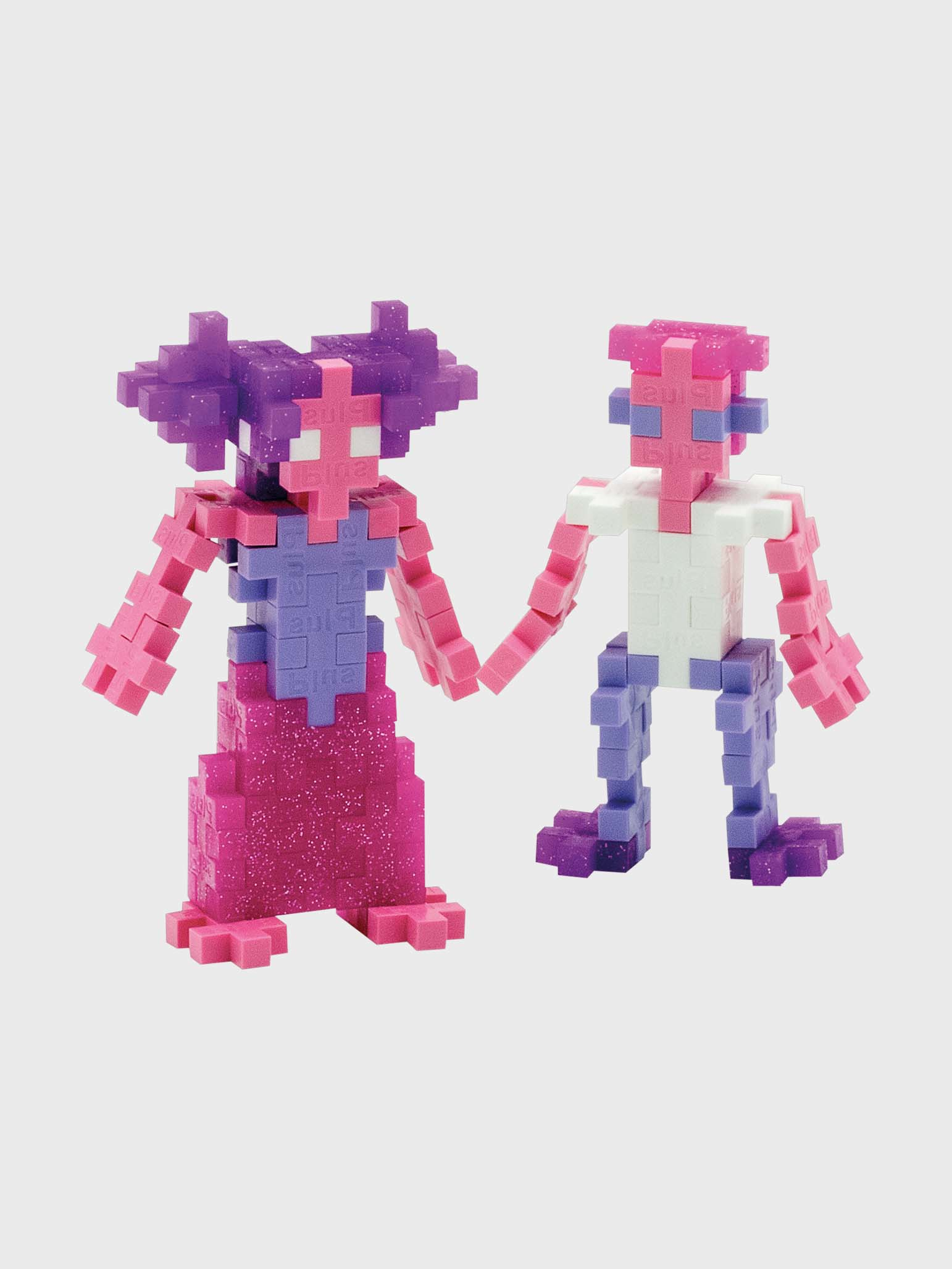 Zwei Blockfiguren halten Hände, eine in Pink und Lila, die andere in Pink und Weiß. Sie lächeln.