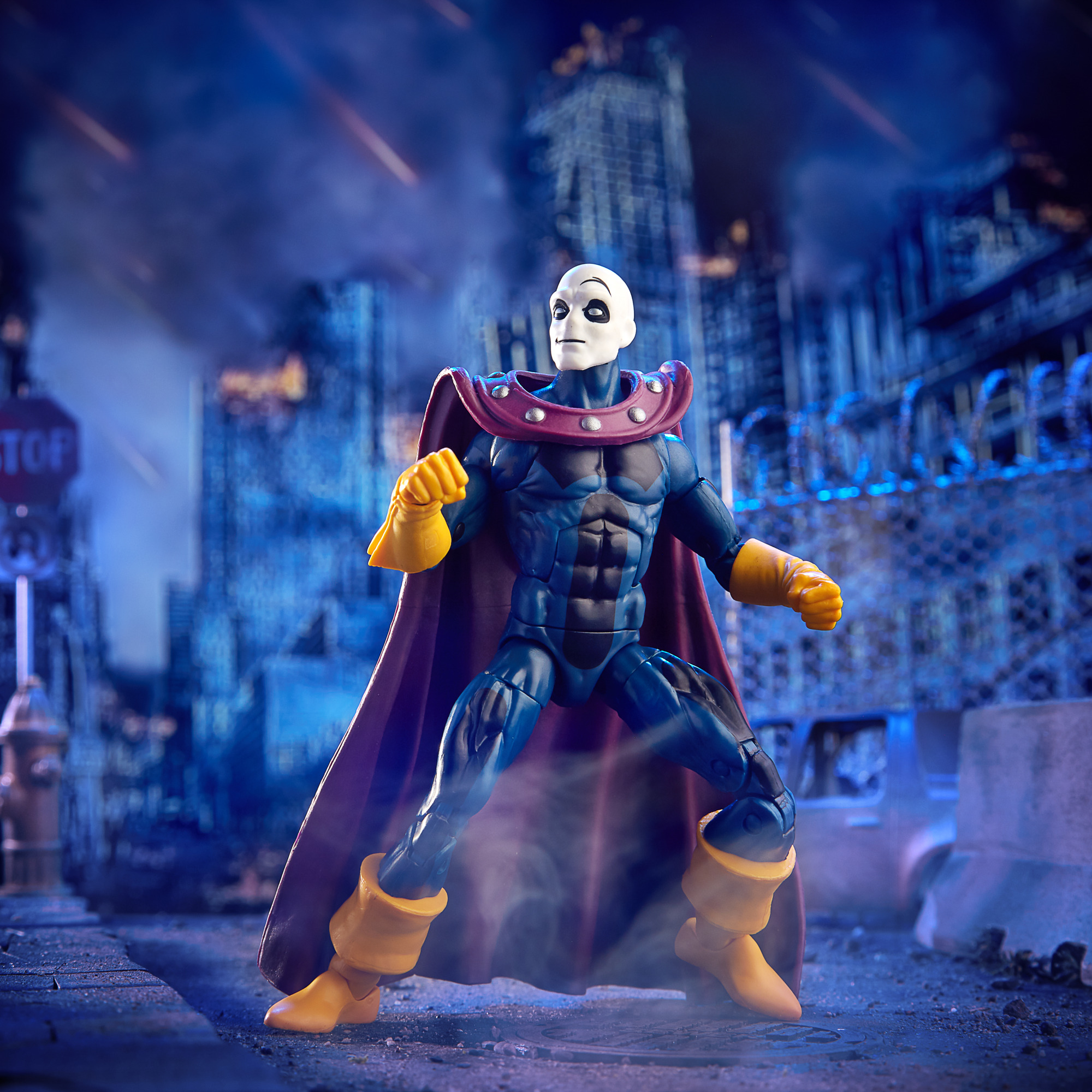 Action figure di un uomo in blu, viola e giallo, con sfondo di città.