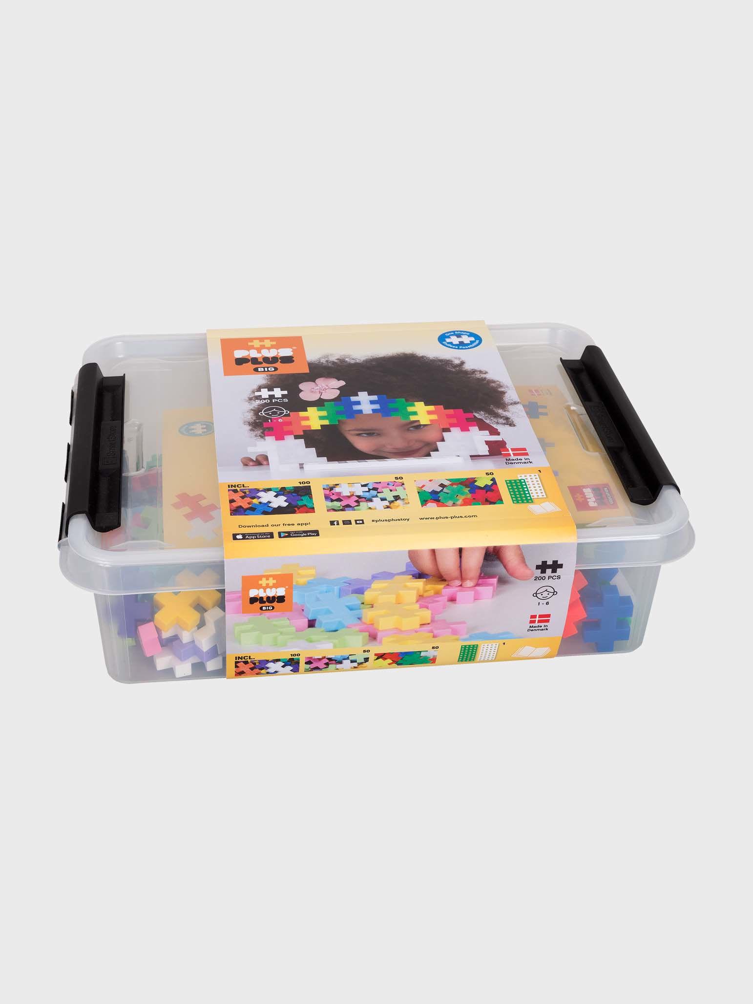 Eine transparente Plastikbox gefüllt mit Plus-Plus Bausteinen, mit einem bunten Bild oben drauf.