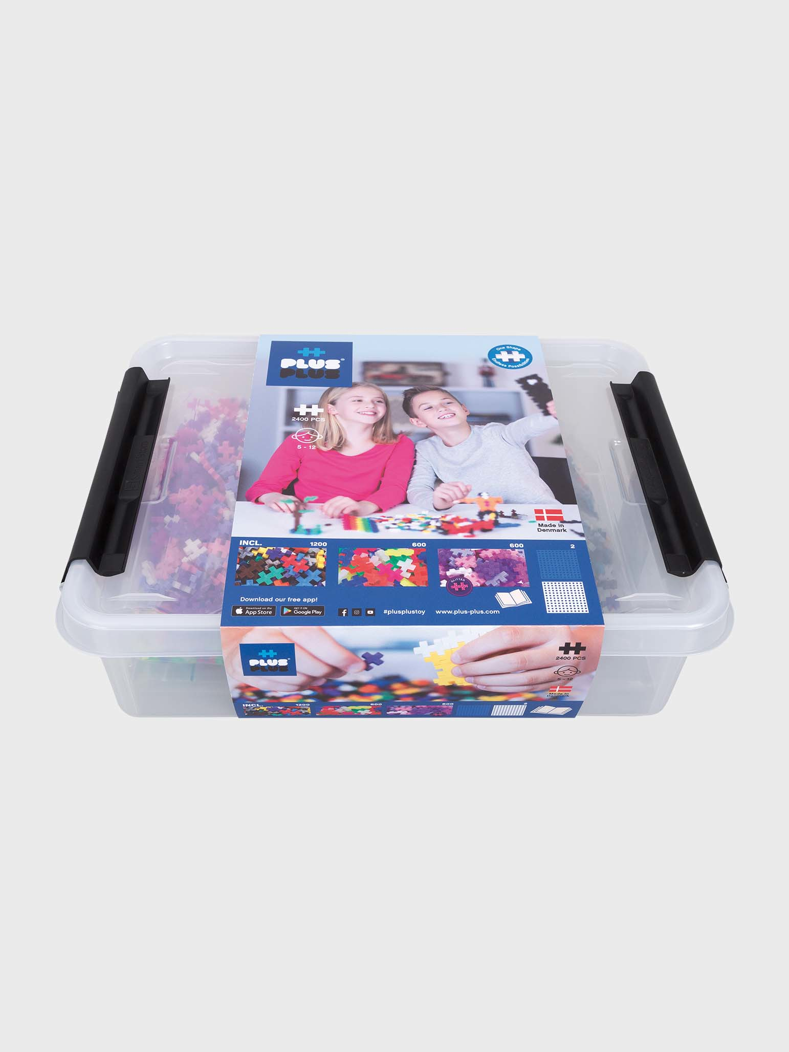 Eine transparente Kunststoffbox enthält farbenfrohe Plus-Plus-Blöcke. Zwei Kinder und Blöcke auf dem Etikett.