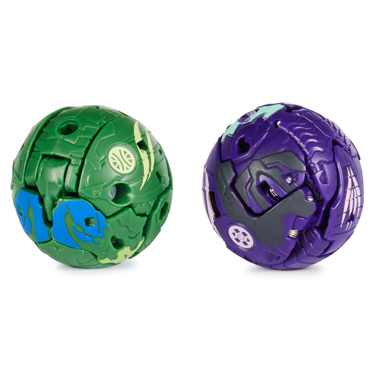 Zwei kugelförmige Bakugan-Spielzeuge. Eines grün und blau, eines lila und grau. Beide sind in Kugelform.