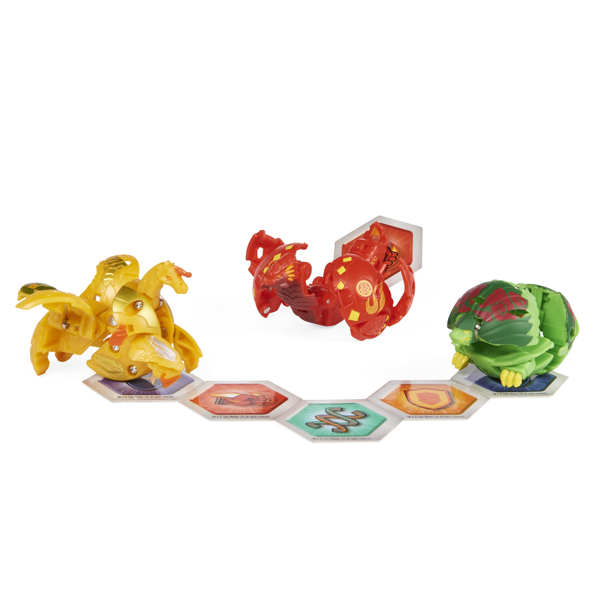 Trzy zabawki Bakugan w postaci kul i stworów, wraz z sześciokątnymi kartami do gry. Jasno kolorowe.