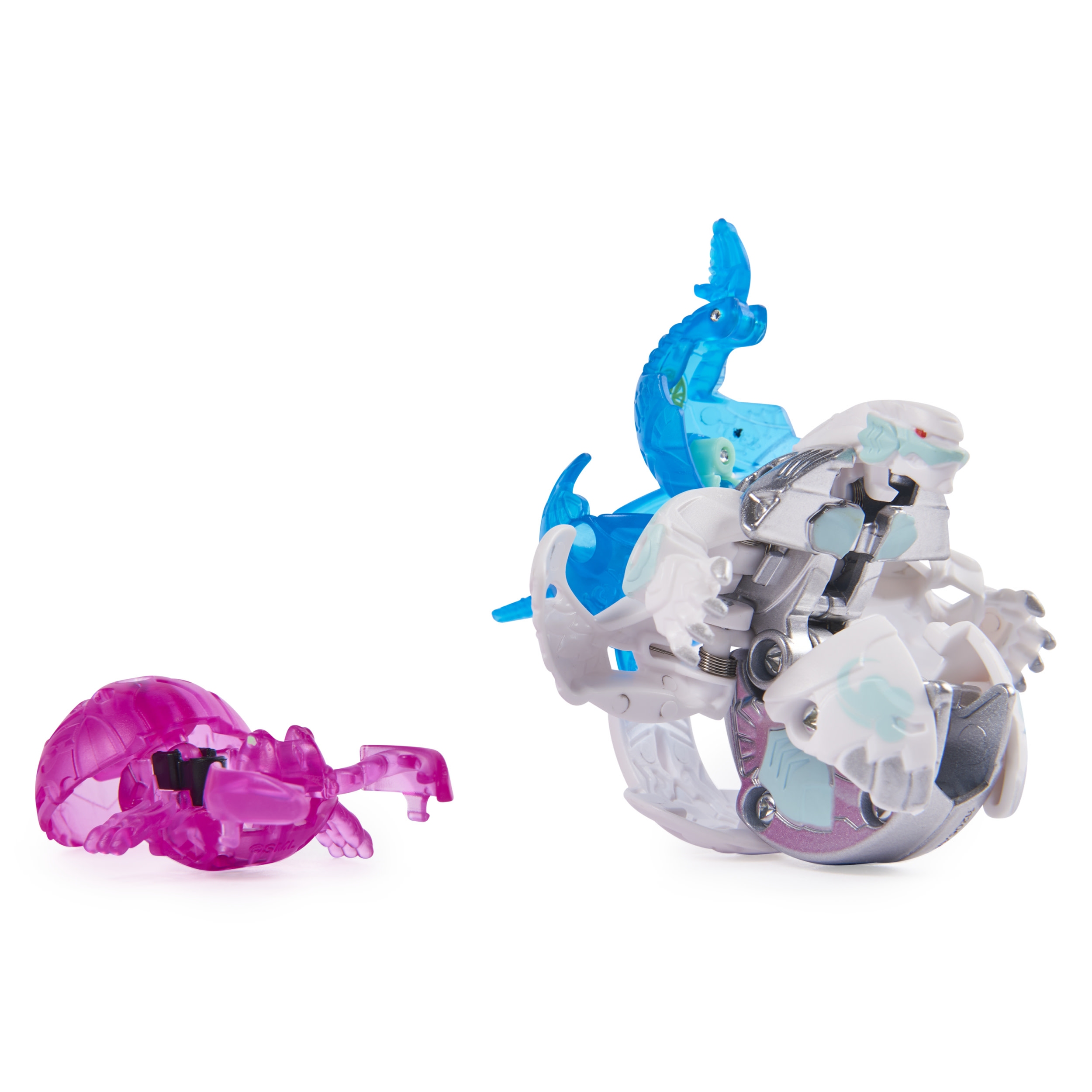 Trzy zabawki Bakugan: różowa, niebieska i biała. Są w różnych fazach transformacji.