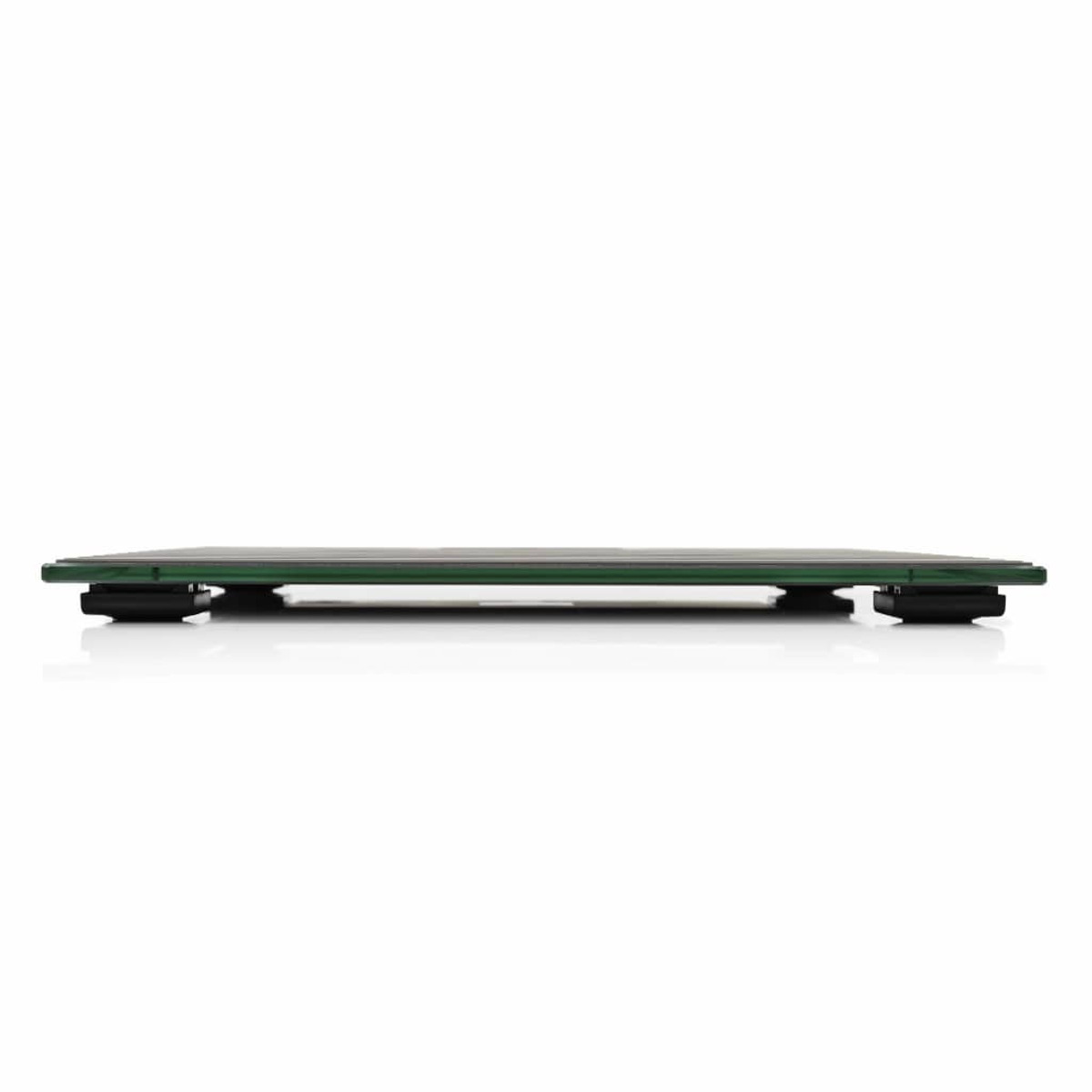 Une vue latérale d'une balance sur une surface blanche. Elle a un dessus vert et une base noire.