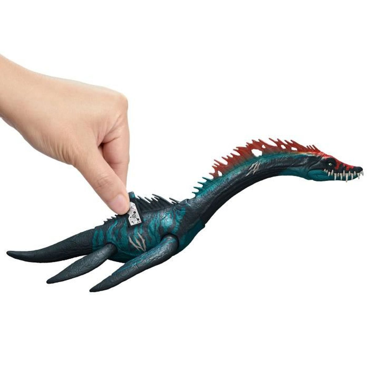Una mano sosteniendo un dinosaurio de juguete con espinas rojas. Tiene dientes blancos y fondo blanco.